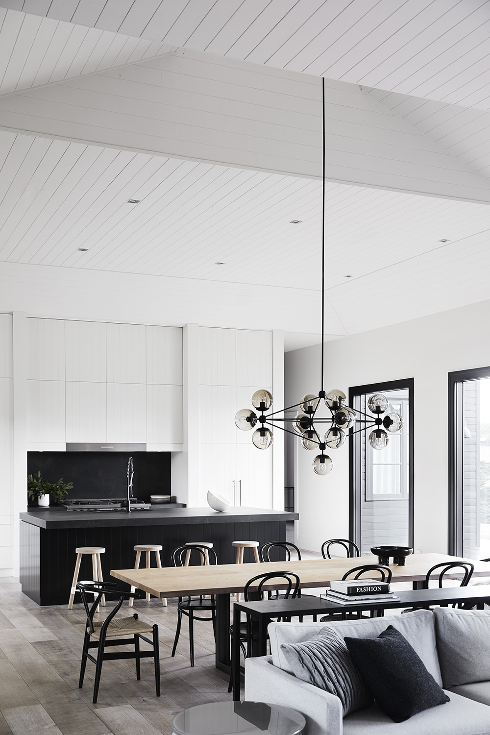 A modern farmhouse interior where the dining room is positioned between the living room and kitchen, all of which are open plan.