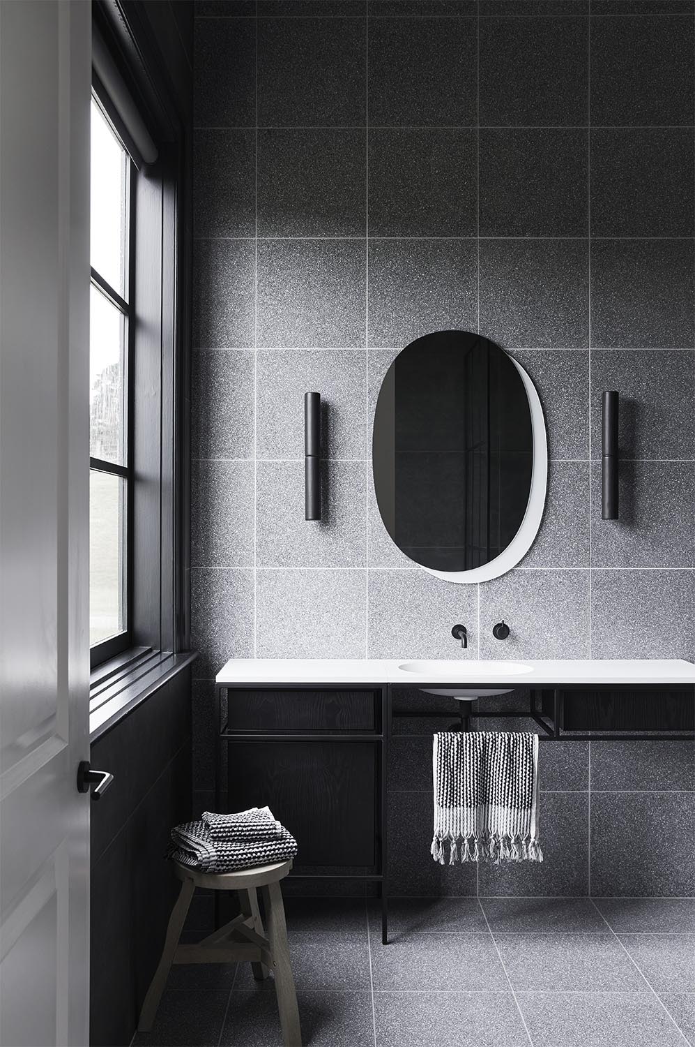 The extremely minimalist and slimline consoles by Ex.t, have black steel frames with white countertops and integrated basins, adding a lightness to the otherwise dark bathrooms.