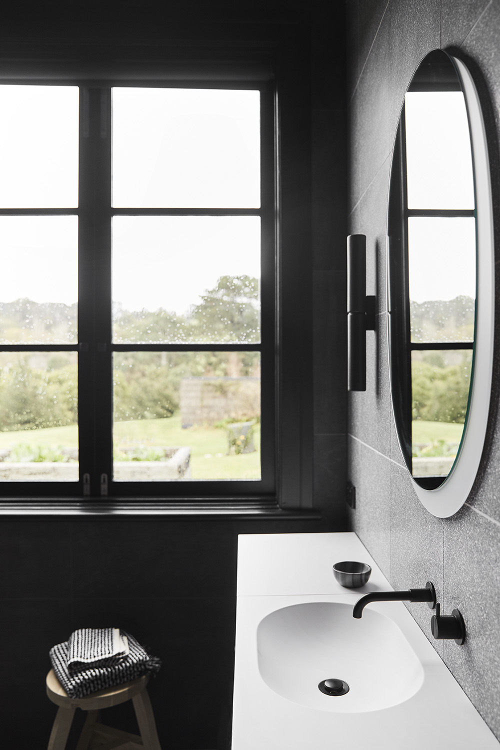 ‘Potter DS’ ceramic wall lights from Anchor Ceramics accent the grey Terrazzo tile walls, and complement the tapware from Brodware.