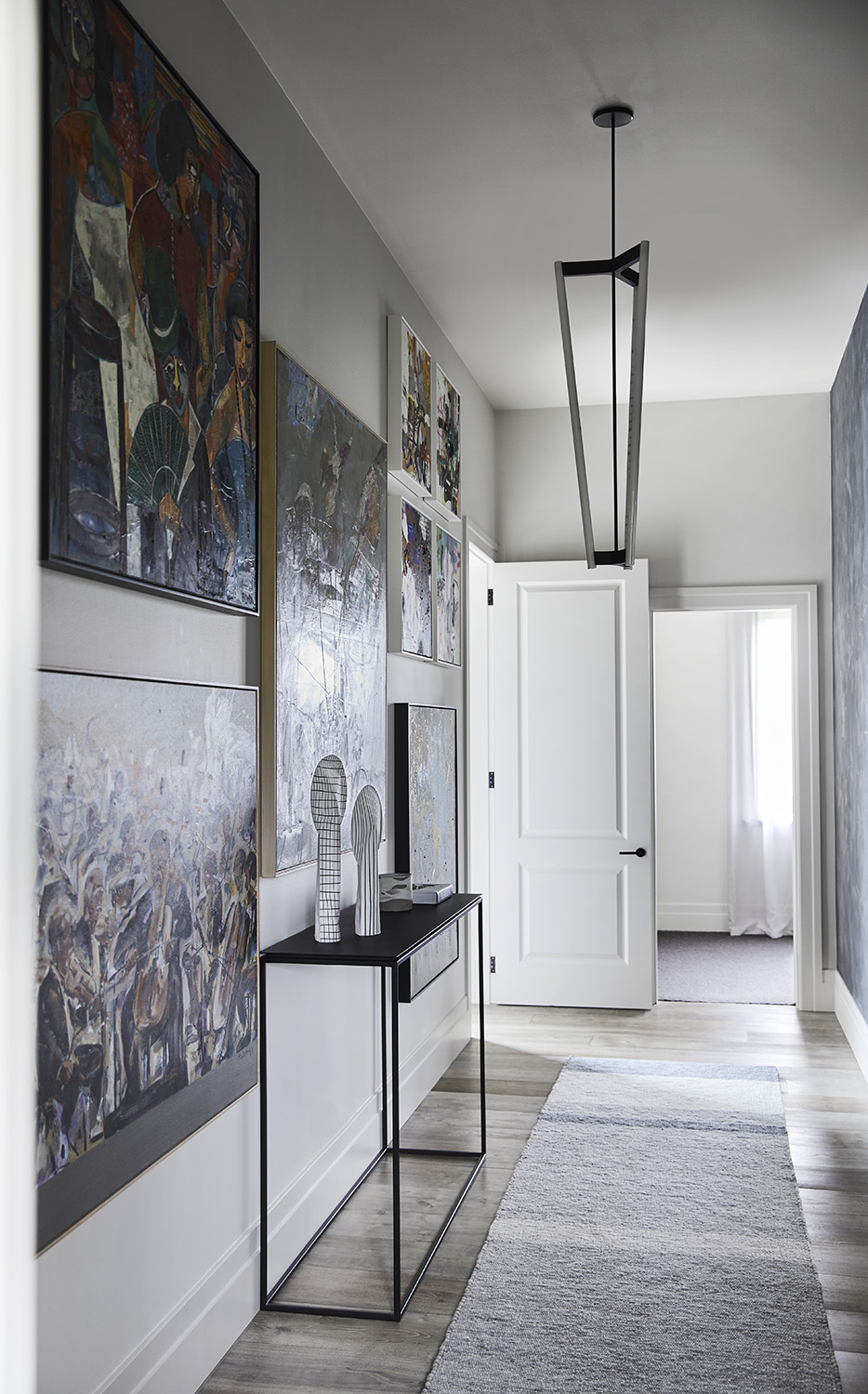 In this modern hallway, artwork covers the walls, while French oak timber flooring can be found throughout the home.