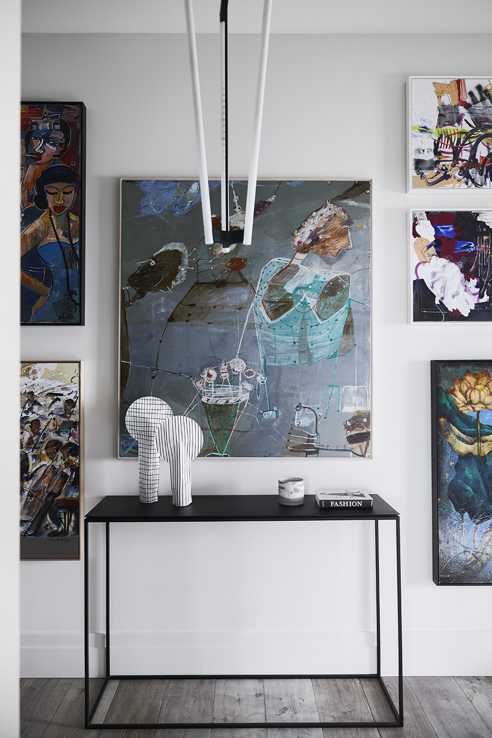 In this modern hallway, artwork covers the walls, while French oak timber flooring can be found throughout the home.