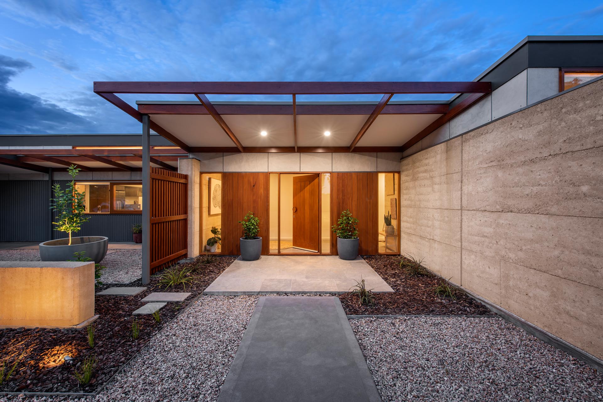 A modern covered front entrance with a large wood front door.