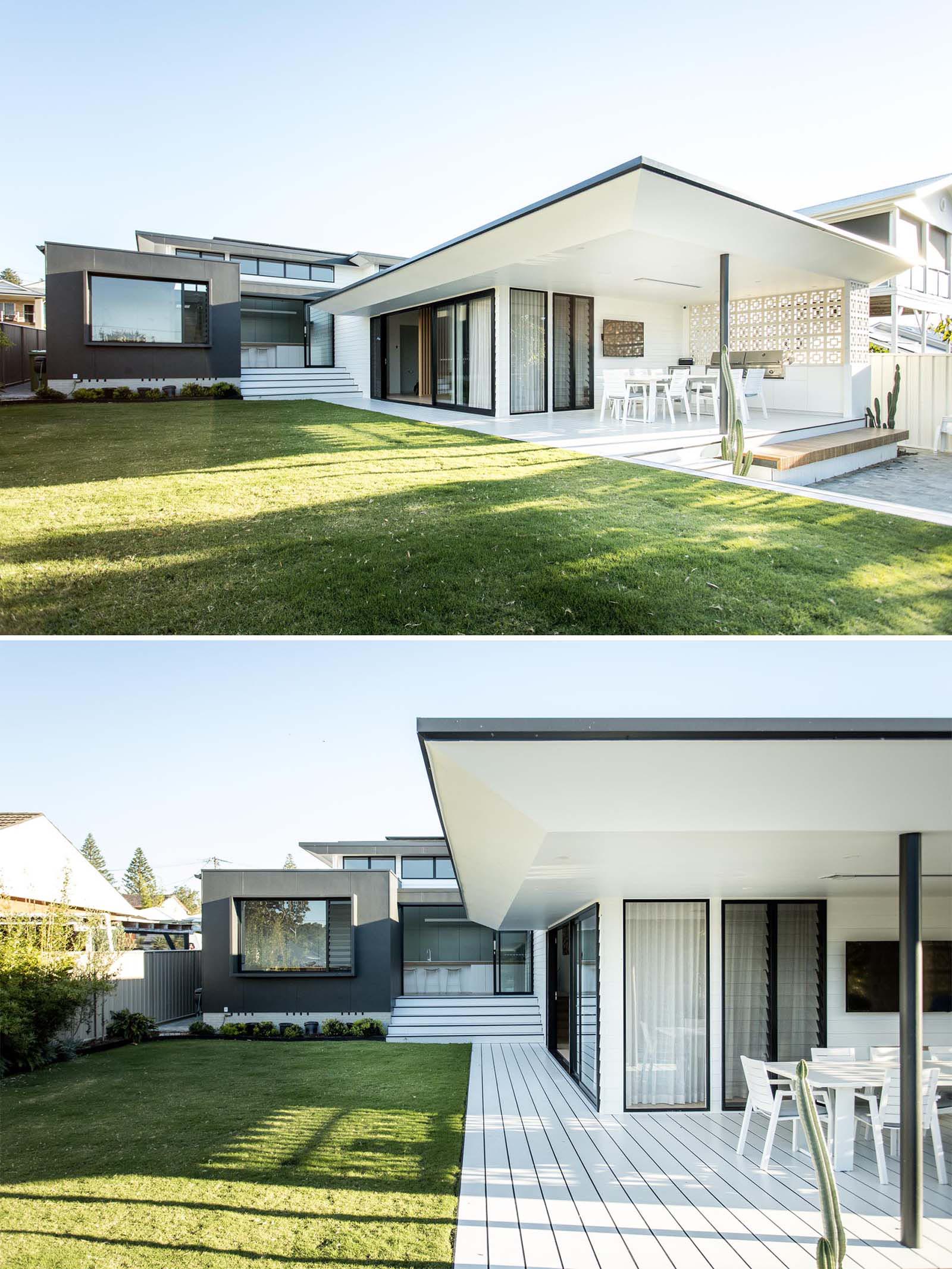 The rear of this modern home includes a covered outdoor kitchen and dining area, as well as a pool and expansive yard, where the home owners can relax and give the children space to roam.