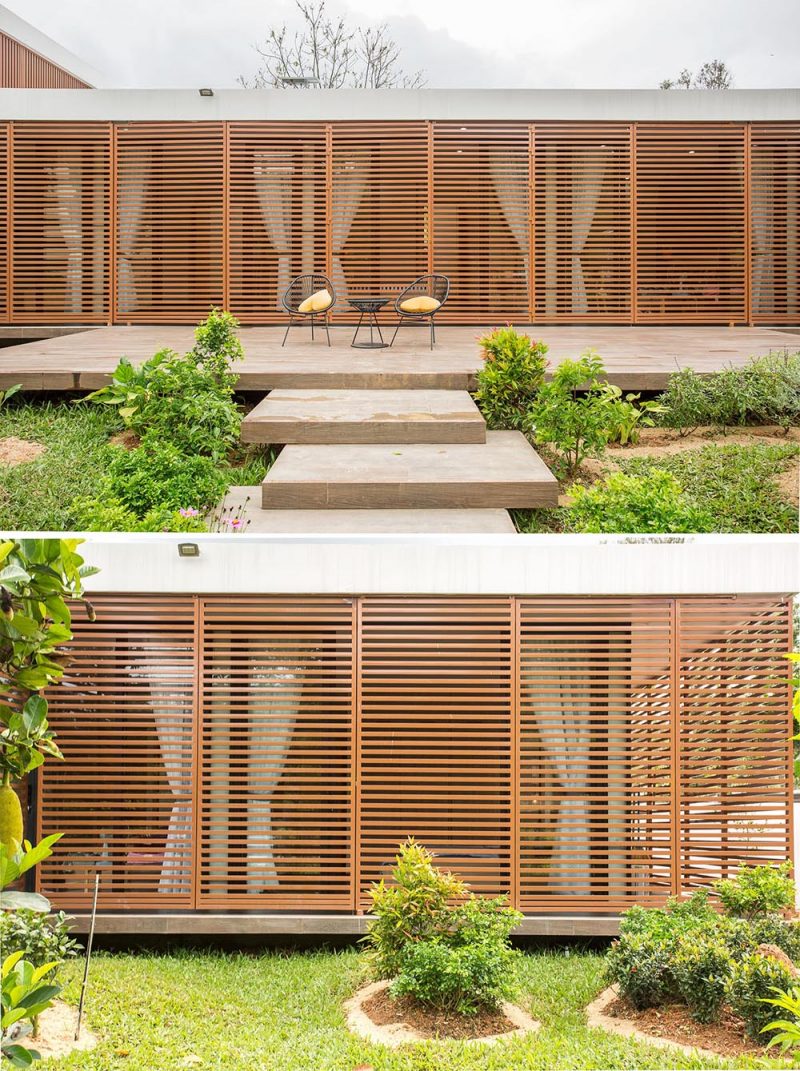 A modern house with operable metal screens that wrap around the exterior and provide an outdoor corridor.