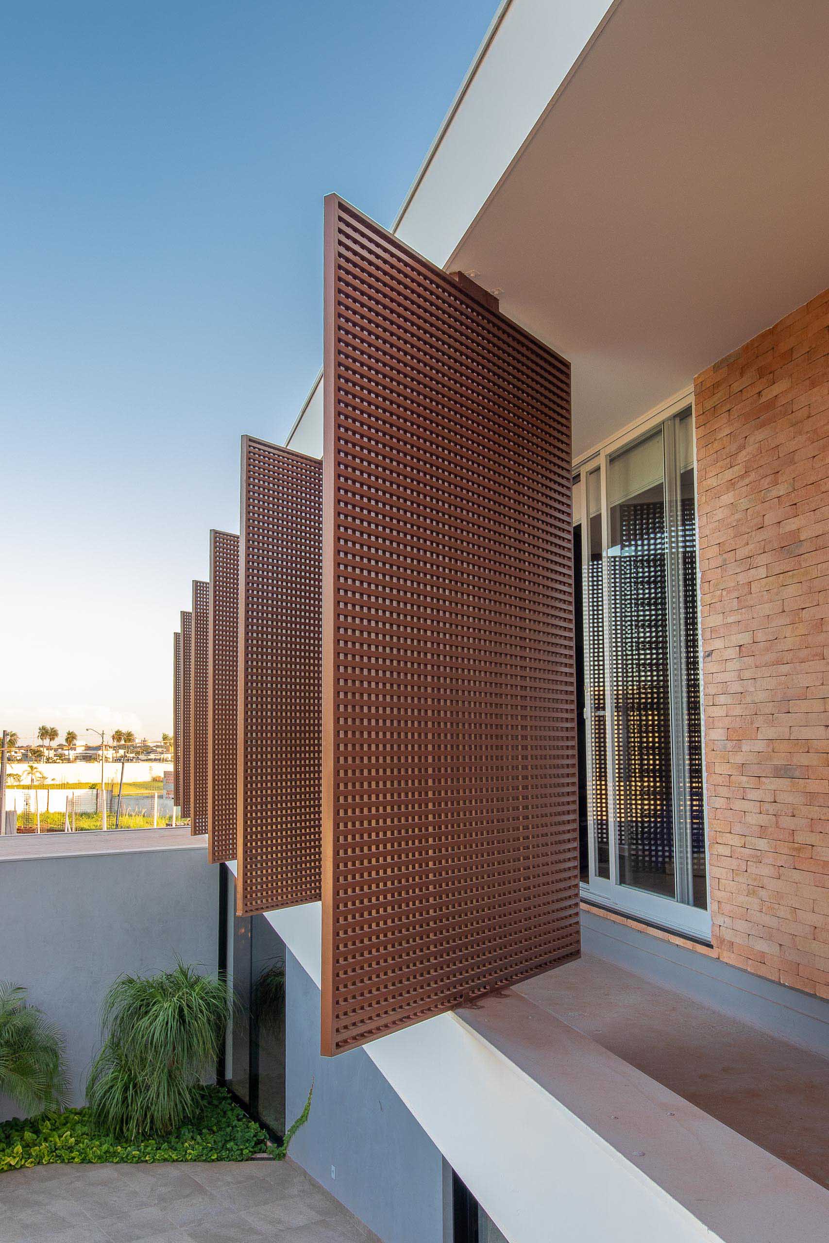 A modern house with screens that shade the interior rooms.