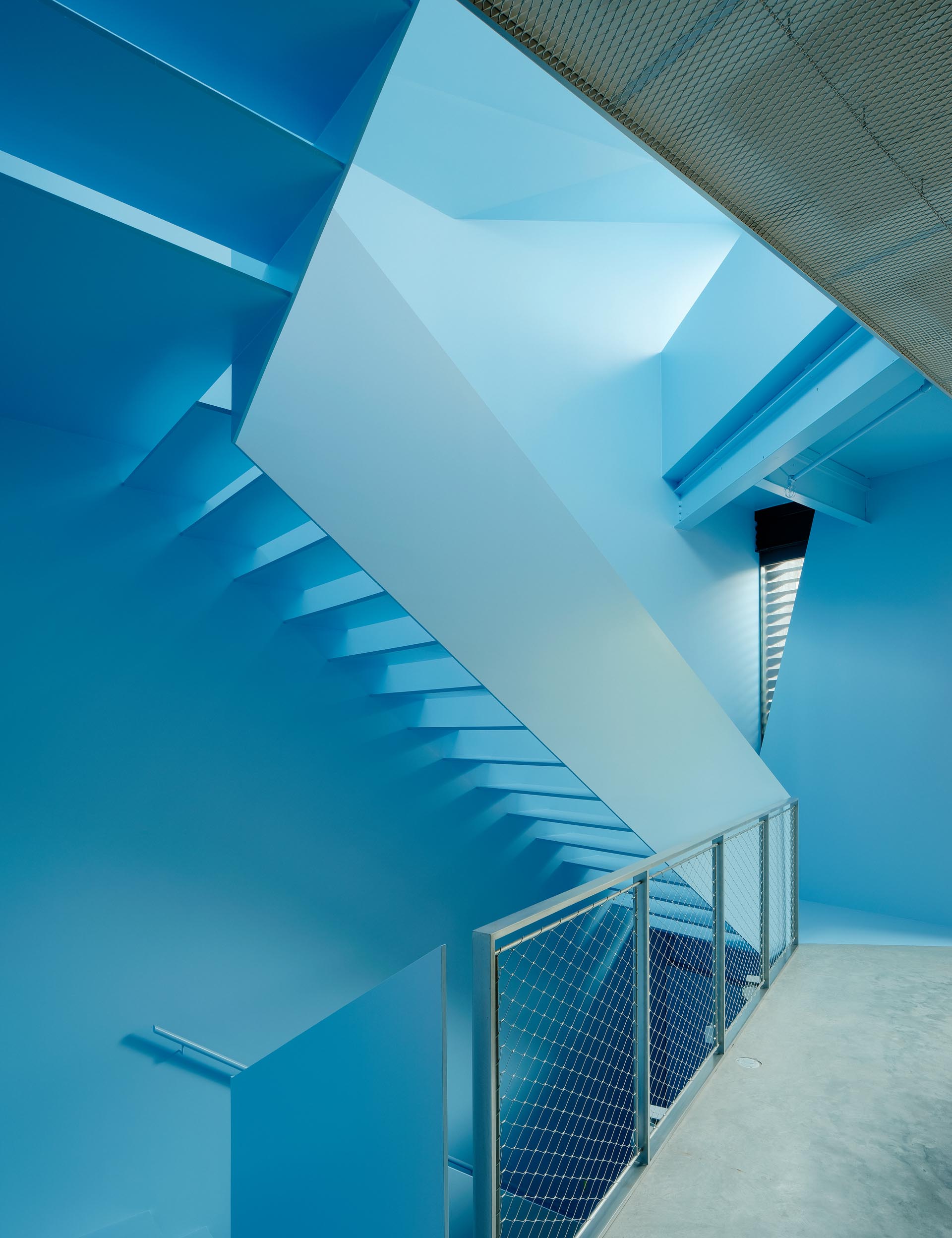 A modern home with a pastel blue staircase.