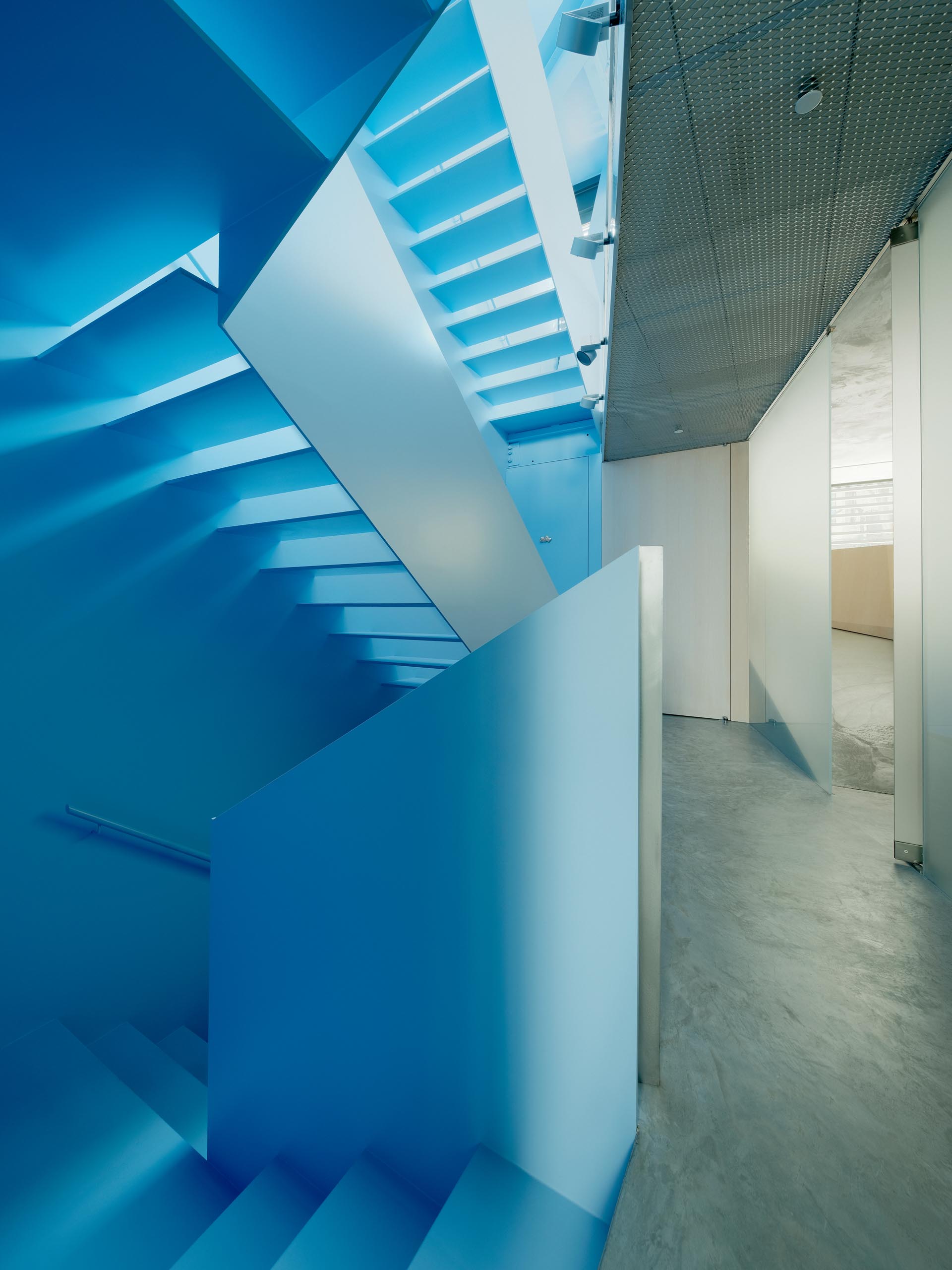 A modern house interior with a pastel blue staircase.