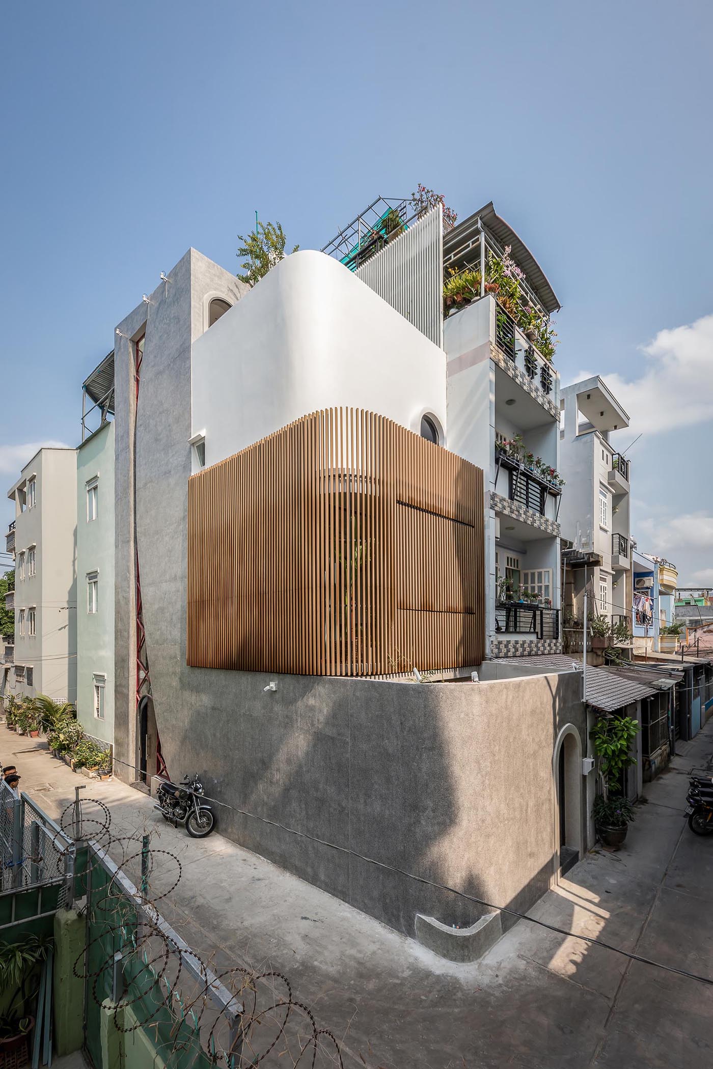 A modern concrete home with a curved wood slat wall.