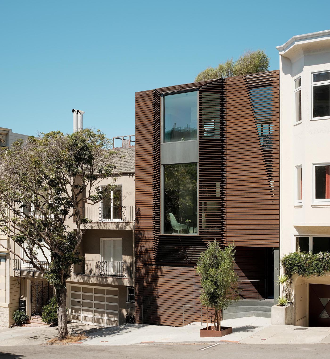 A modern home with a wood exterior and bay windows.