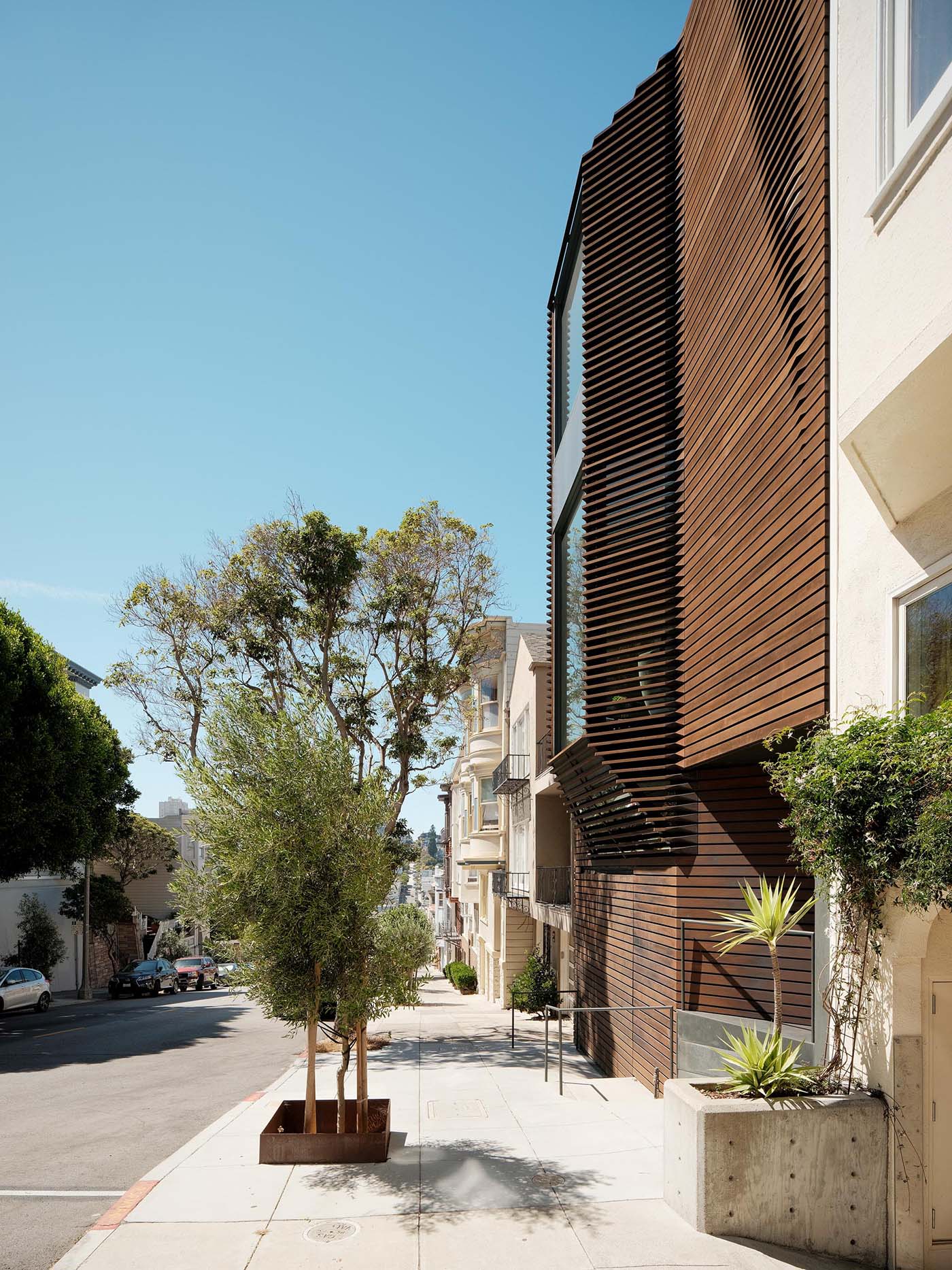 A modern home with a wood exterior and bay windows.