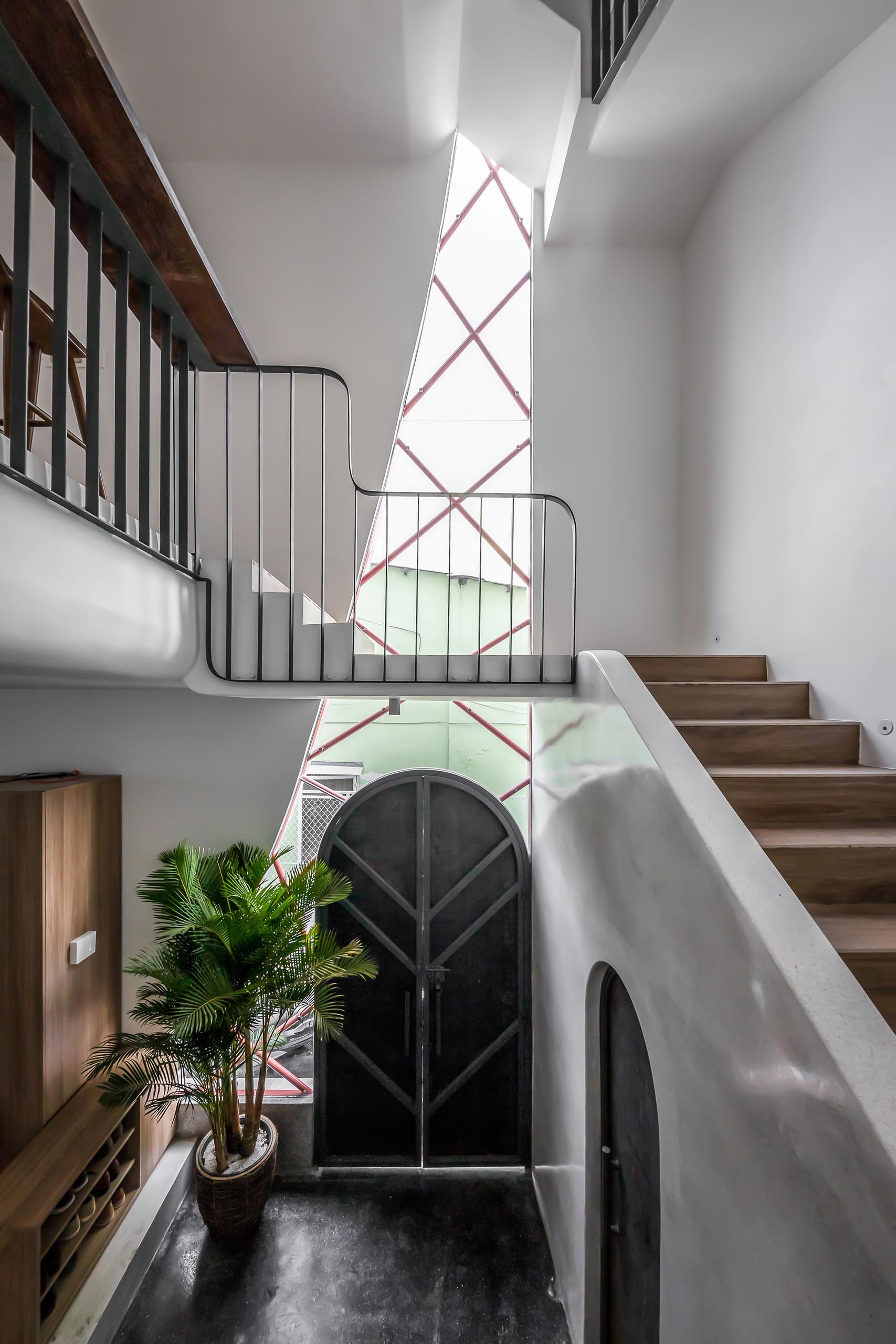 An irregular shaped window fills the entryway and staircase with natural light.