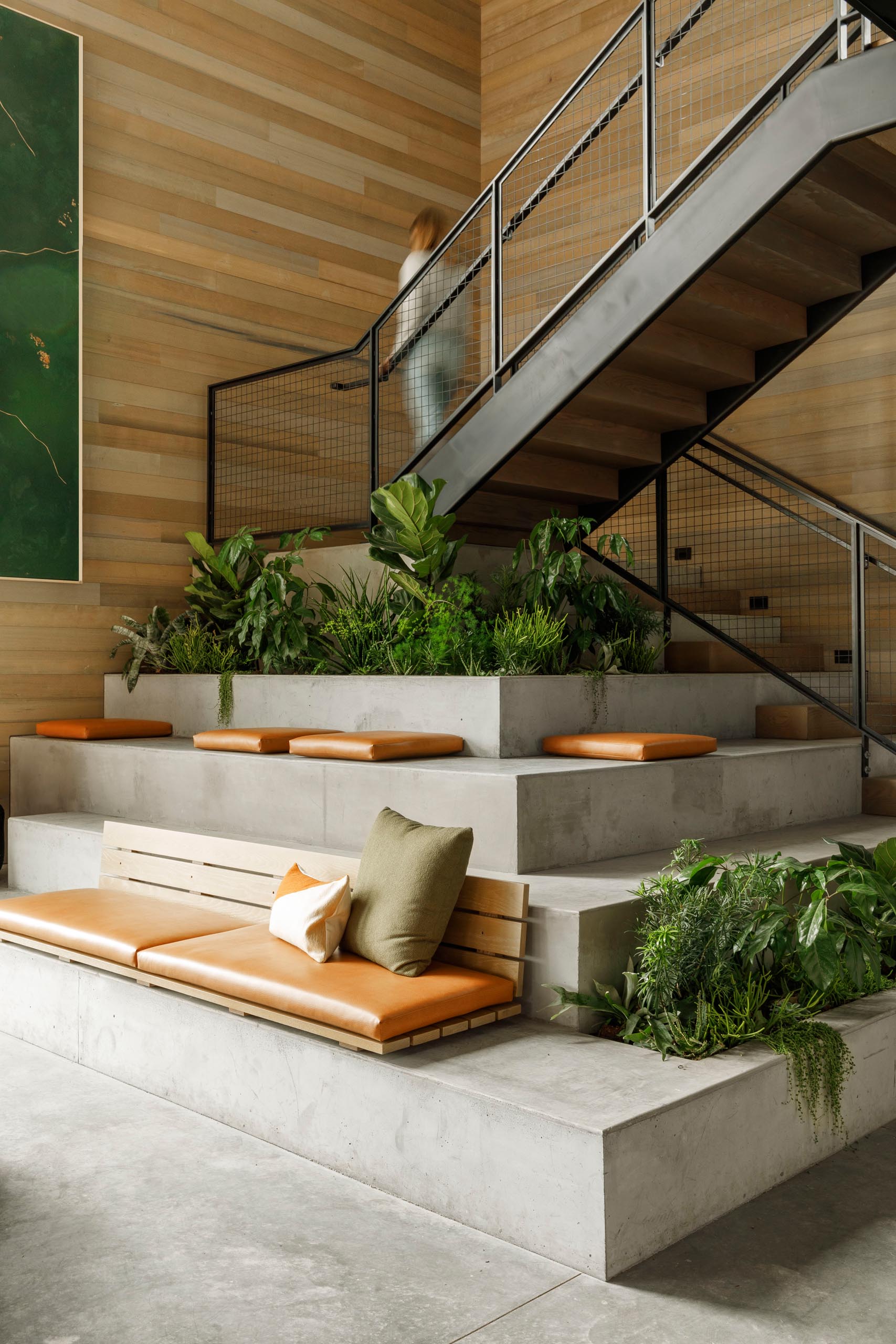 Tiered seating, created as an extension of the stairs, includes built-in planters.