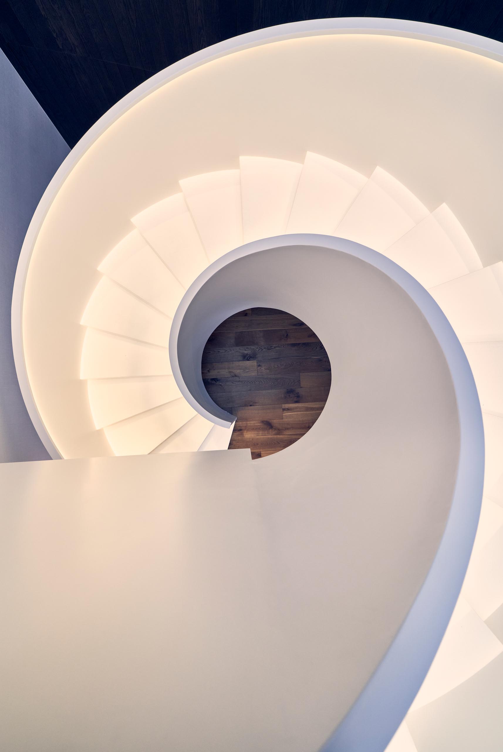 Modern white spiral stairs with hidden lighting.