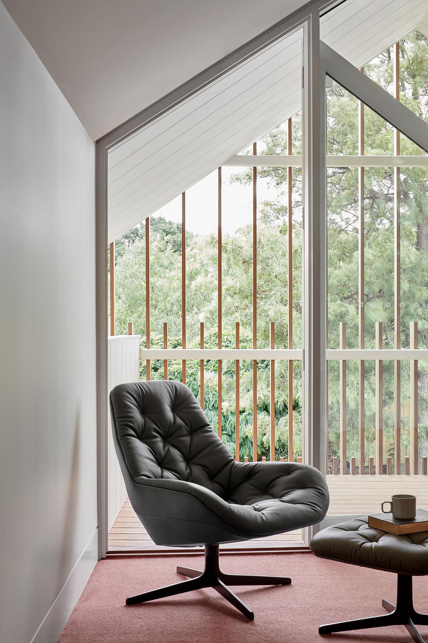 A modern bedroom with floor-to-ceiling windows and doors that opens to a balcony.