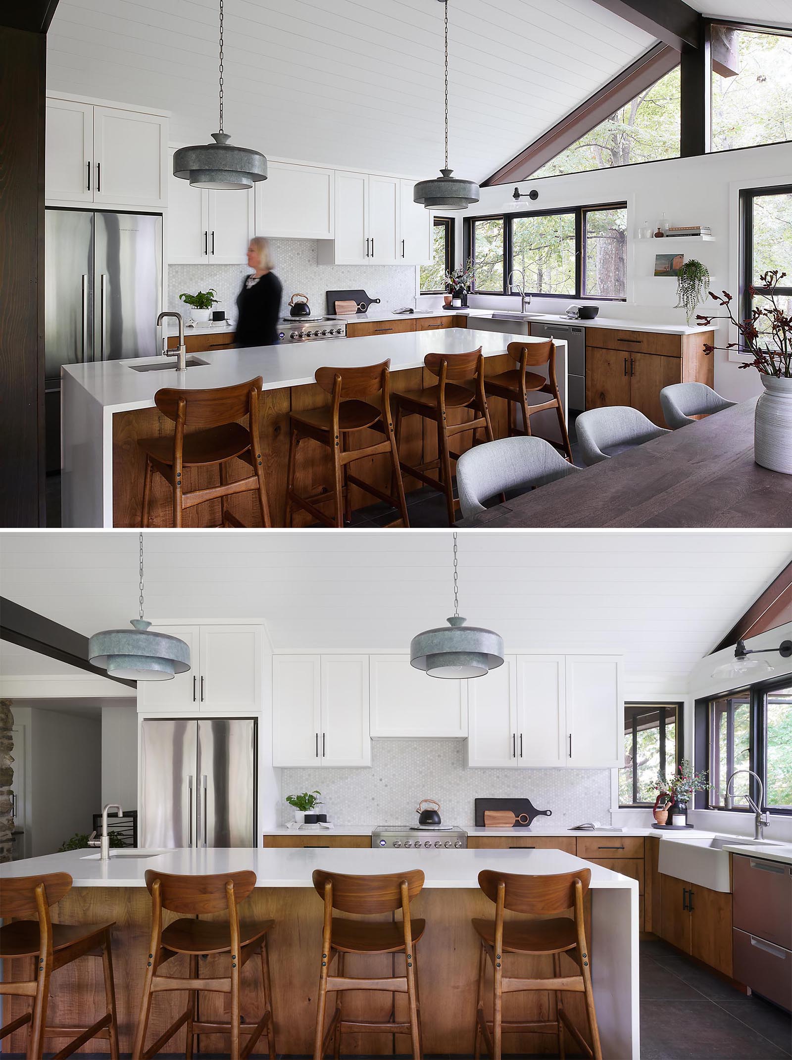 A modern kitchen with a large kitchen island provides ample countertop space, while the upper cabinets have a simple shaker style with black hardware, and the lower cabinets are wood.