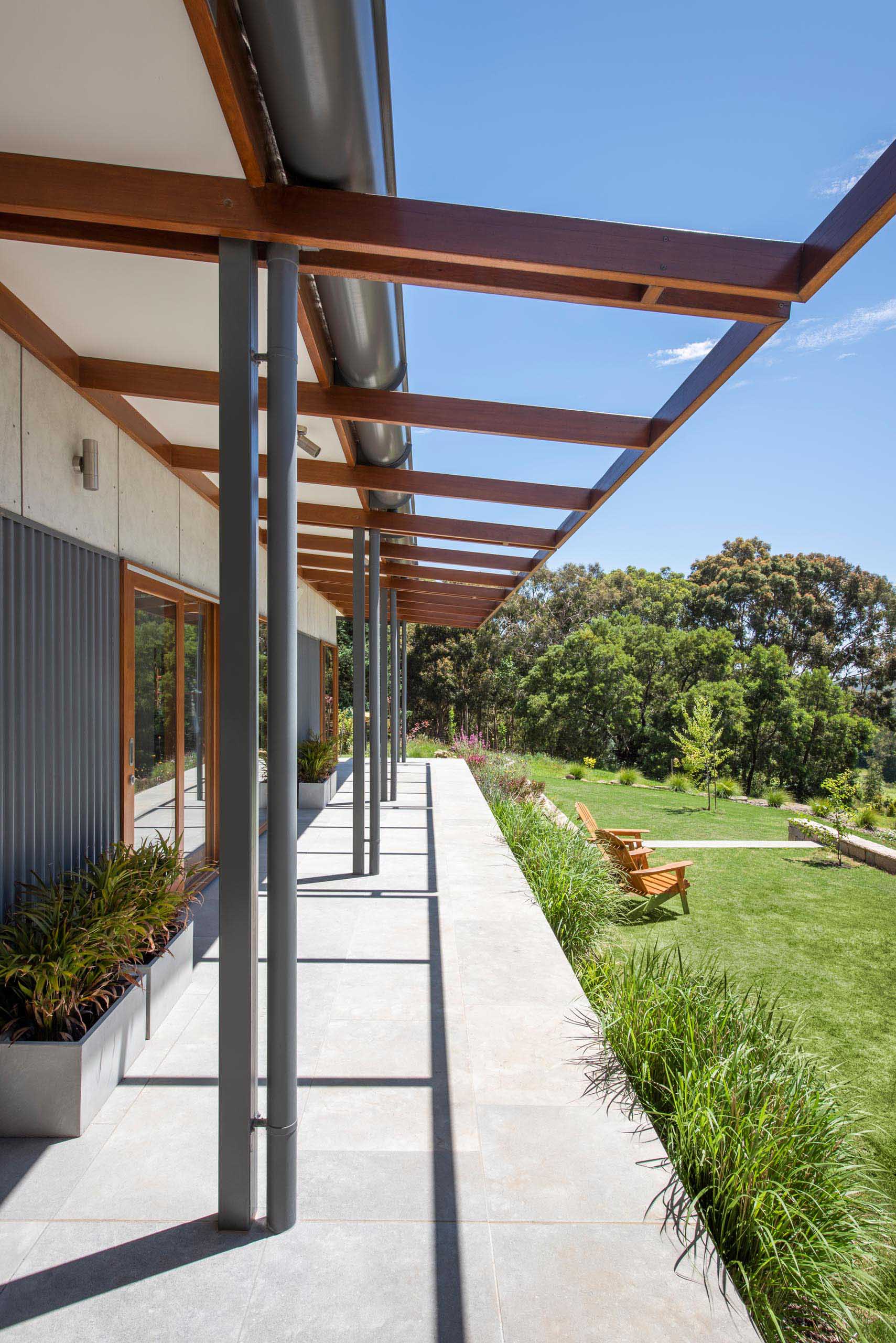 A modern house with a wrap around porch.