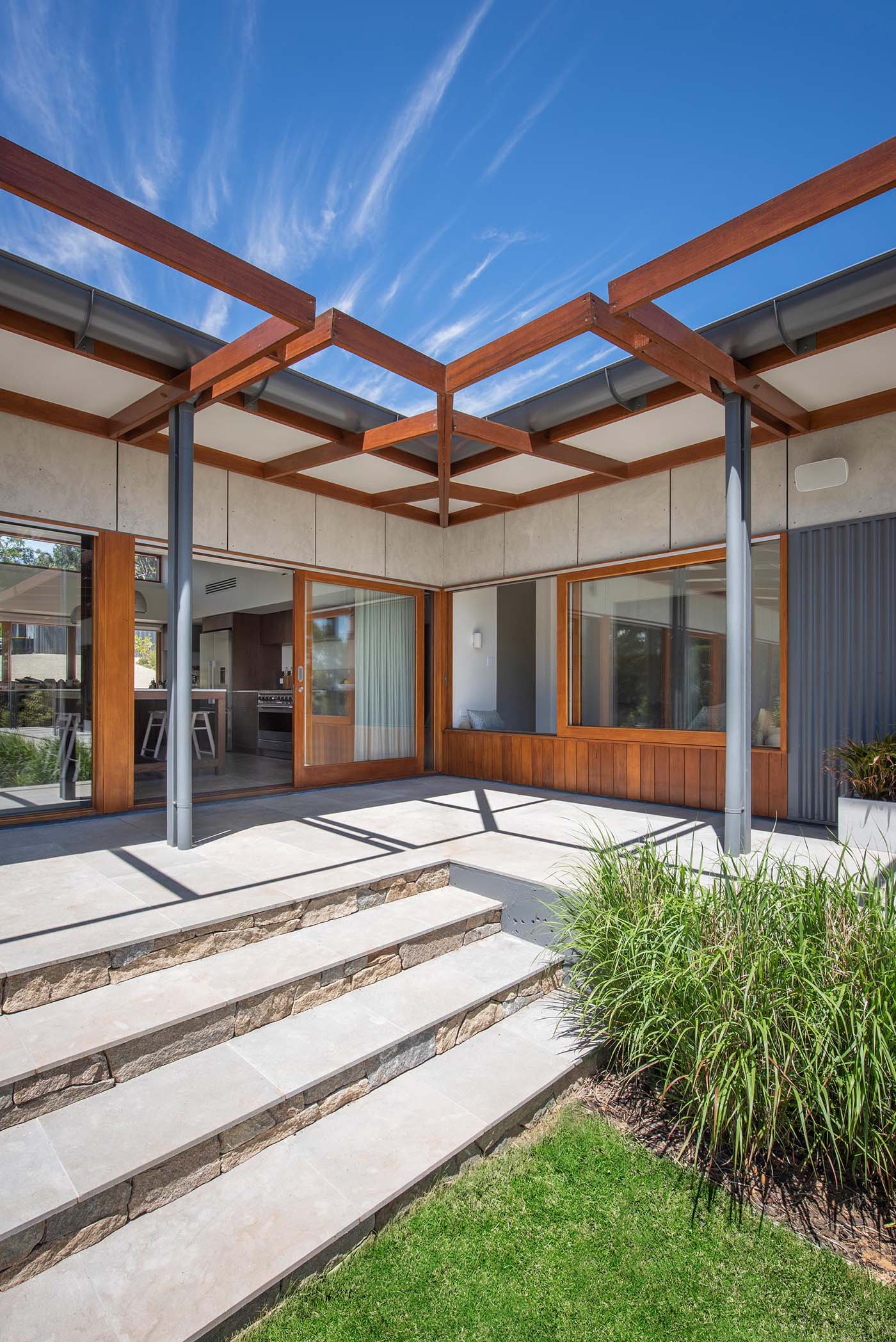 Wood-framed sliding glass doors open the living spaces to a wrap around patio.