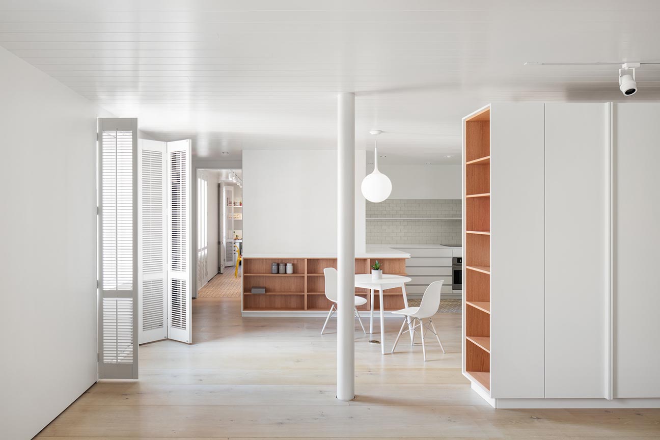 A modern office with wood lined shelves.