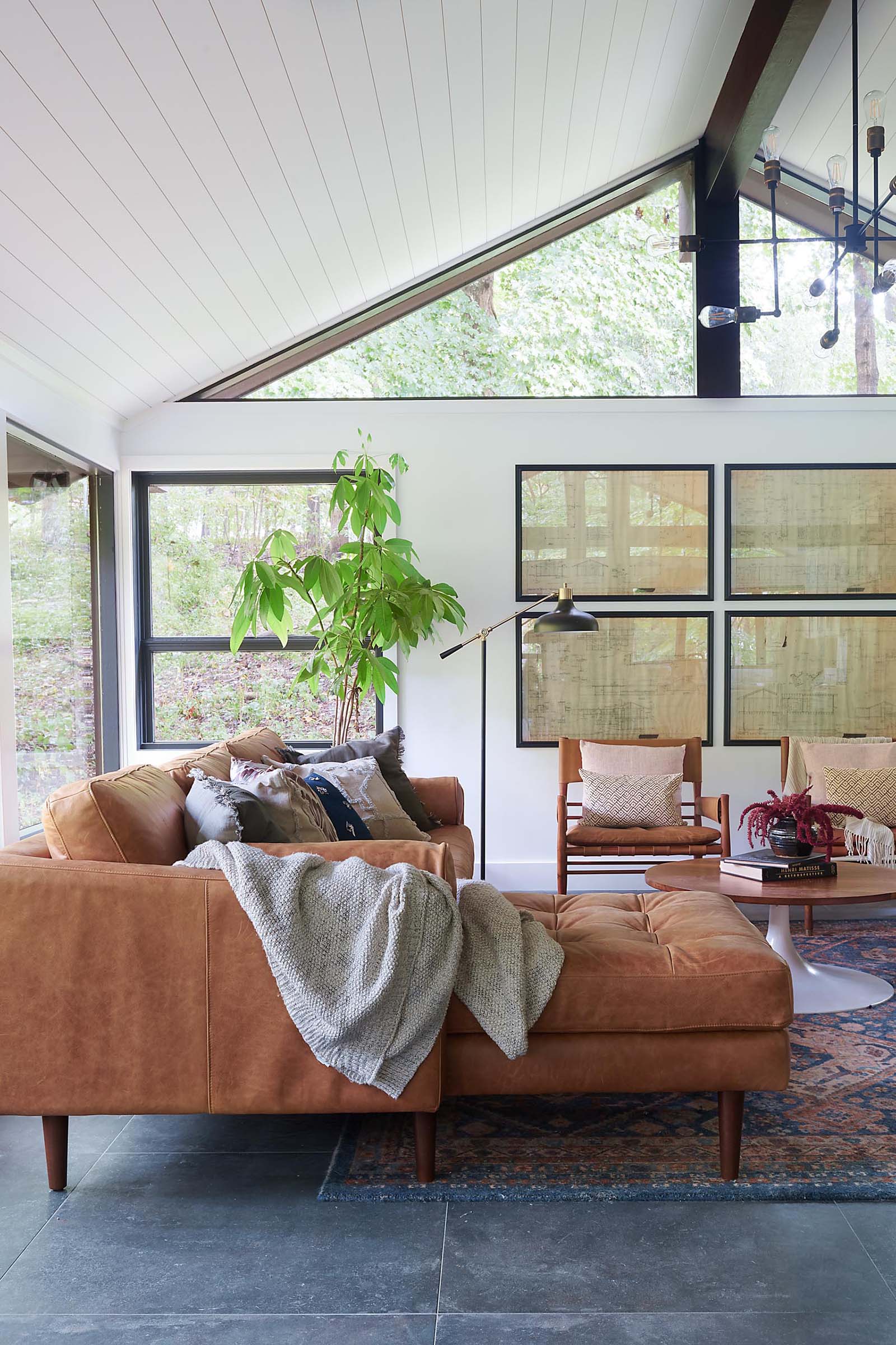 Small details like the dark painted window sashes create a stark, but eye popping contrast of the new white walls and ceiling in this modern living room.