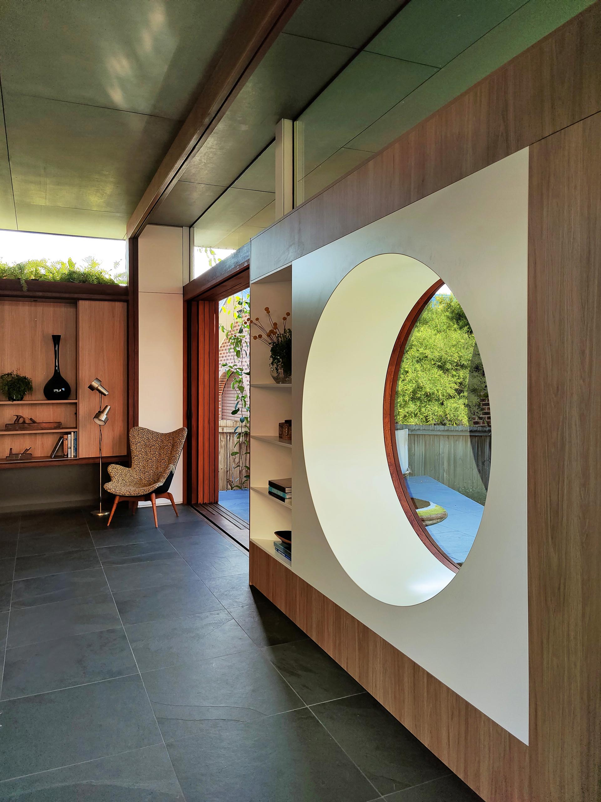 A modern living room with a circular window.