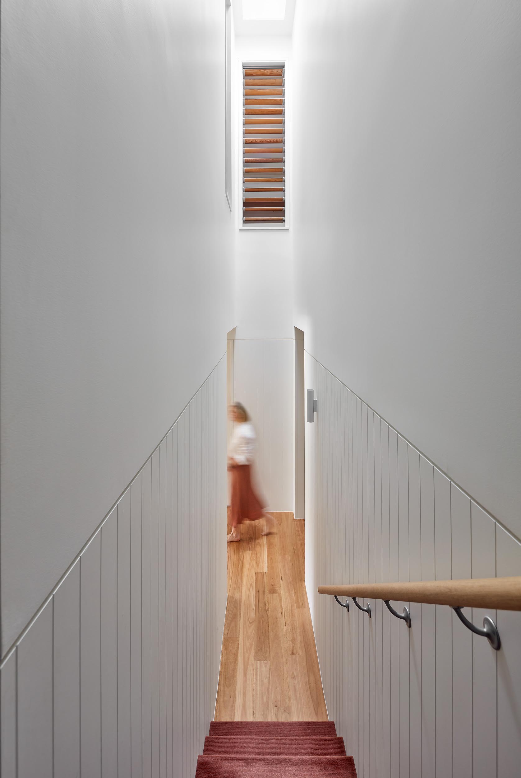 A staircase with a skylight connects the various floors of this renovated home.