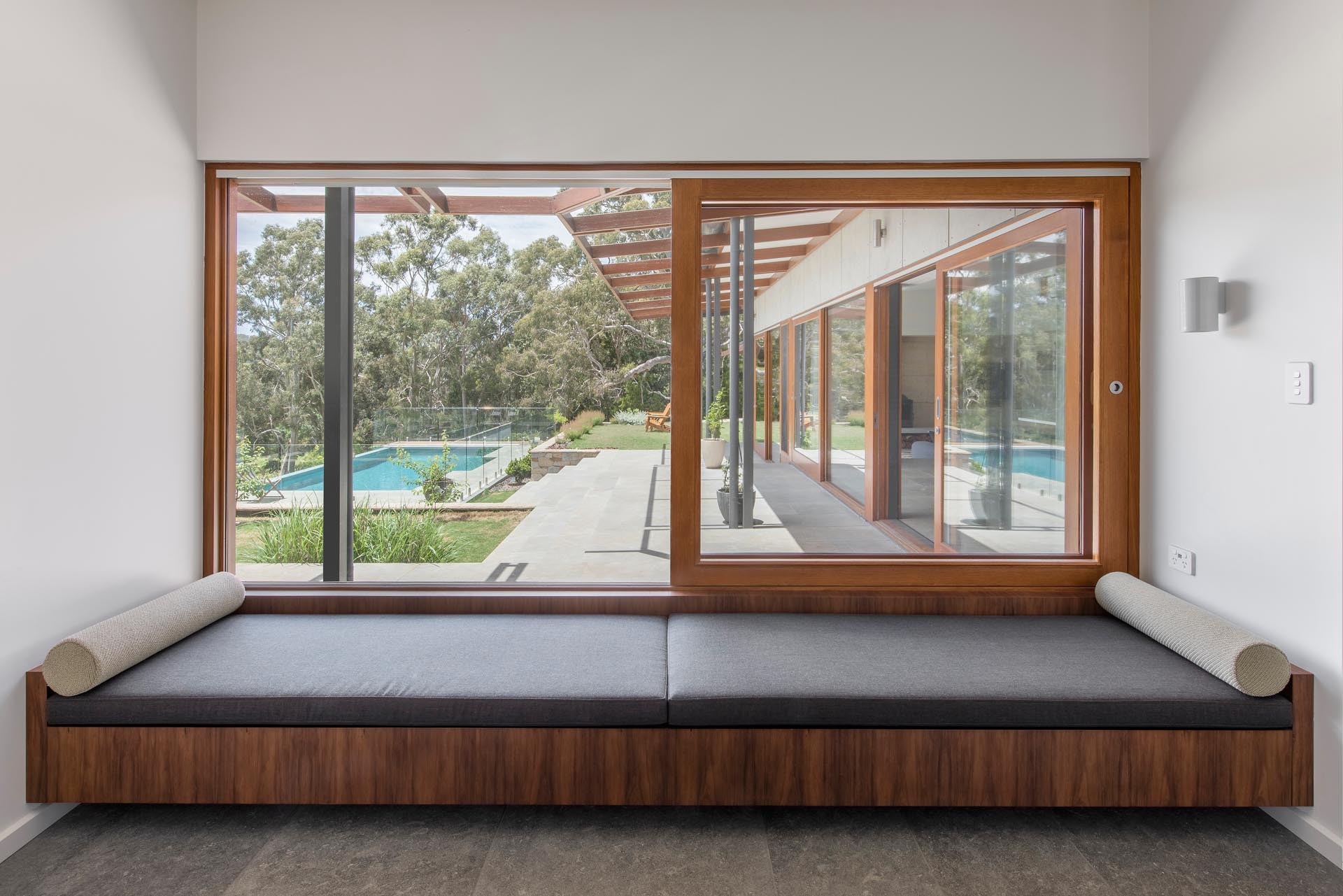 A quieter space in thsi home that also opens to the outdoors, is a full width day bed by the window, that takes advantage of the terrace and pool views.