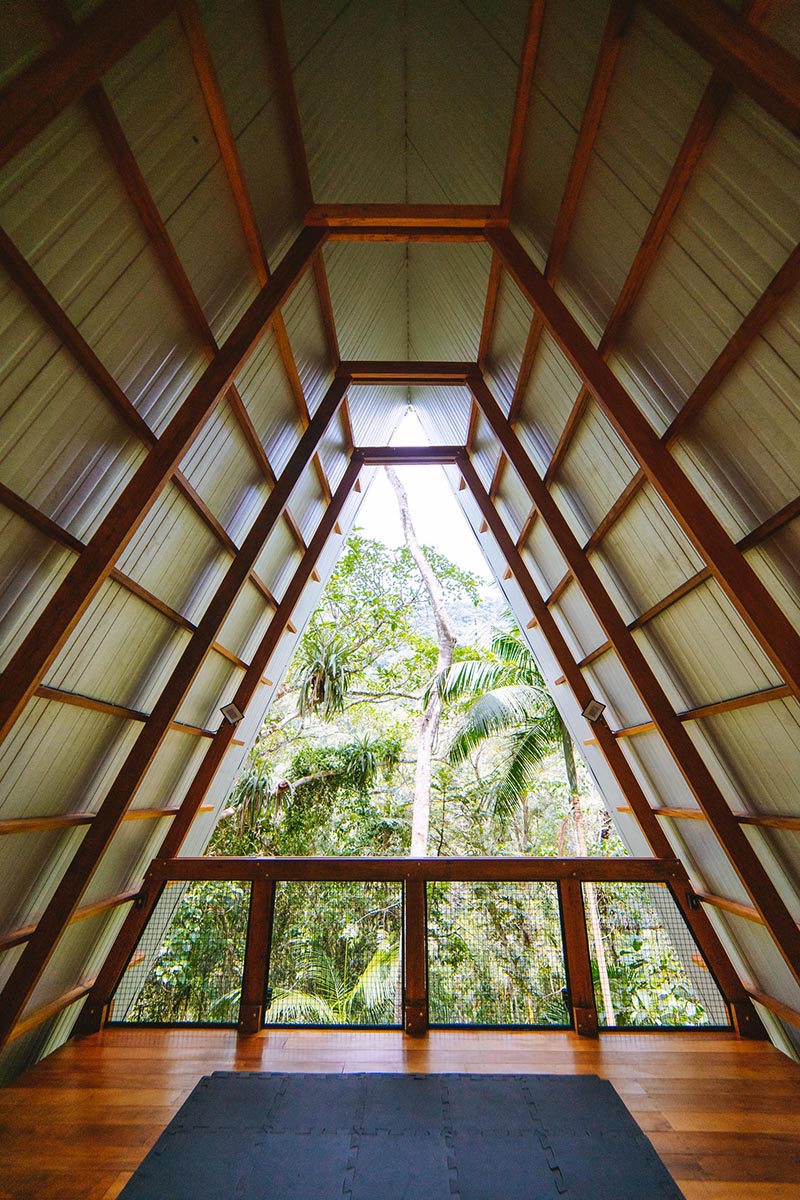 An A-Frame cabin with an open space at the top for yoga and meditating.