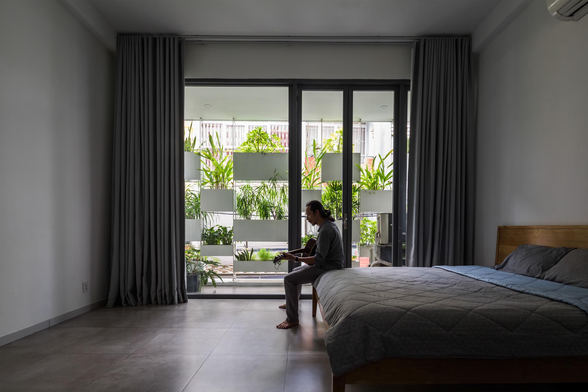 A minimalist bedroom with a view of built-in planters.