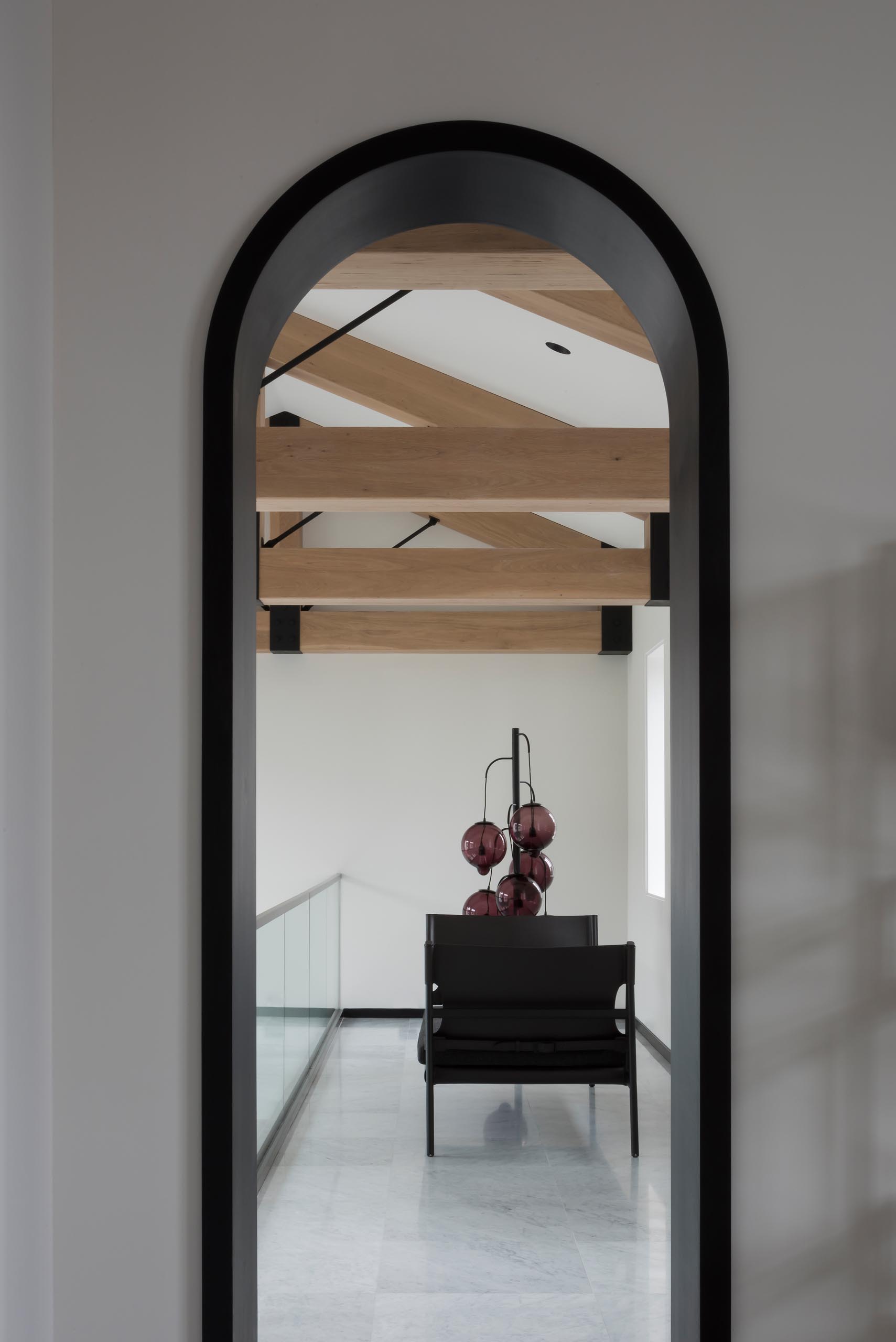 Each of the arched doorways in this modern interior are highlighted by a seamless matte black lining.