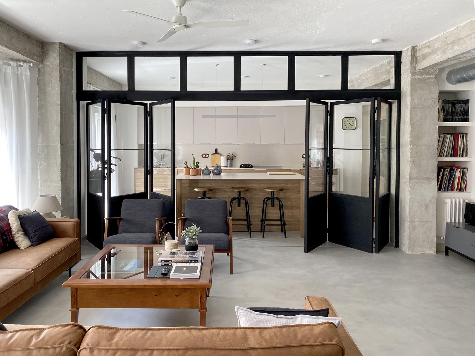 A modern kitchen can be closed off from the living room by black-framed doors with windows.