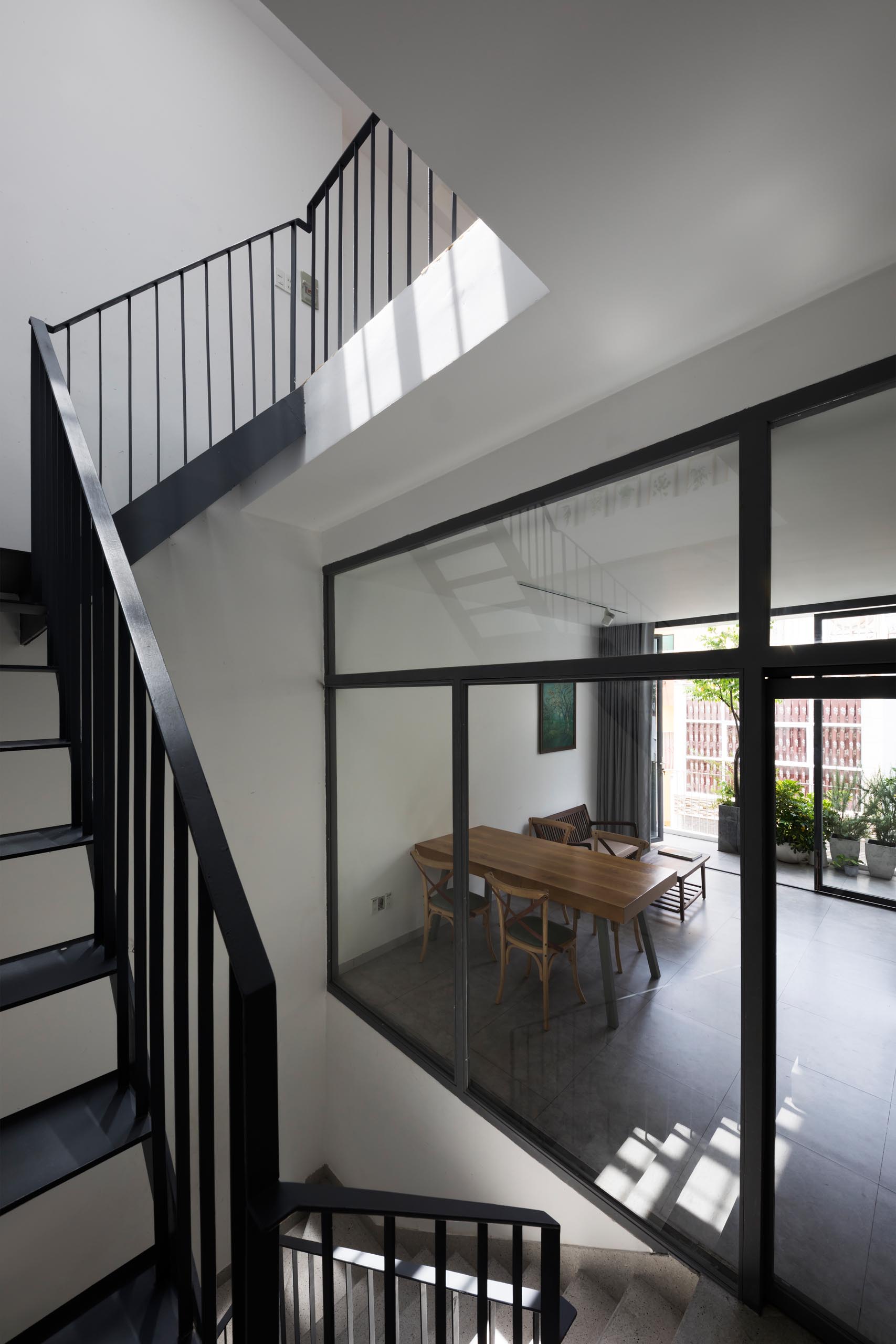 A modern home with black steel stairs and glass walls.