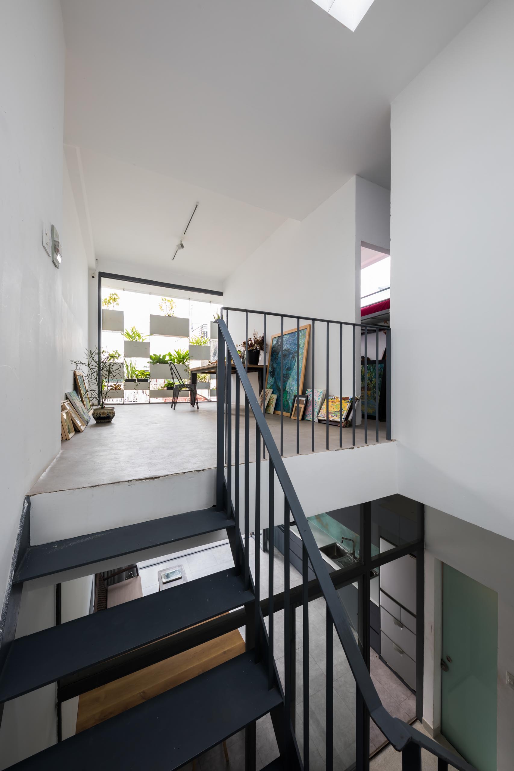 At the top of stairs in this modern home, there's an art studio with simple white walls and space for creating.