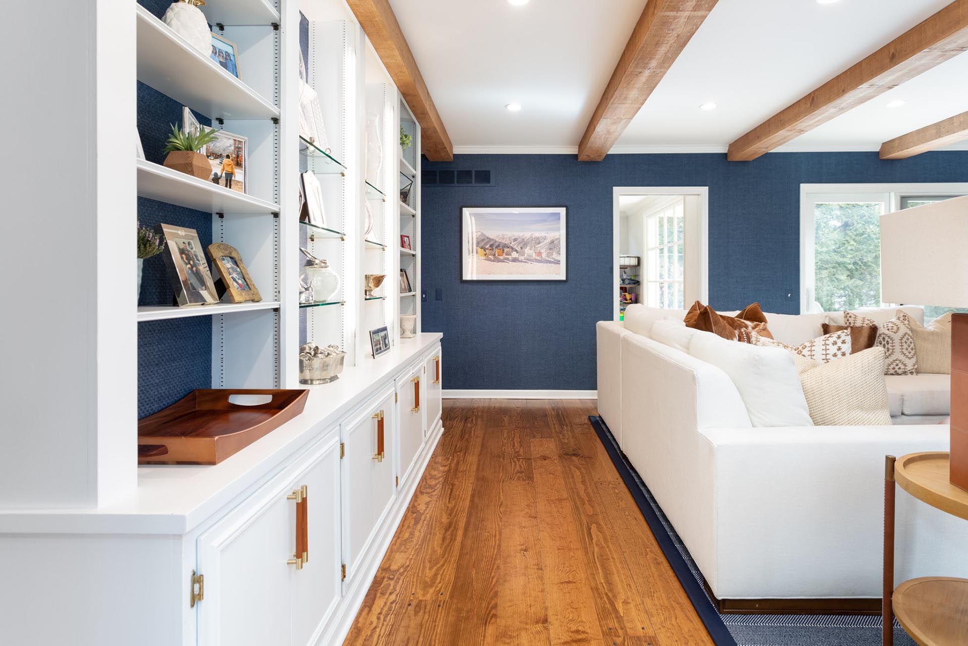 In this living room, reclaimed oak wood beams complement the fireplace mantle and the wide plank oak flooring, adding the perfect amount of warmth and coziness.