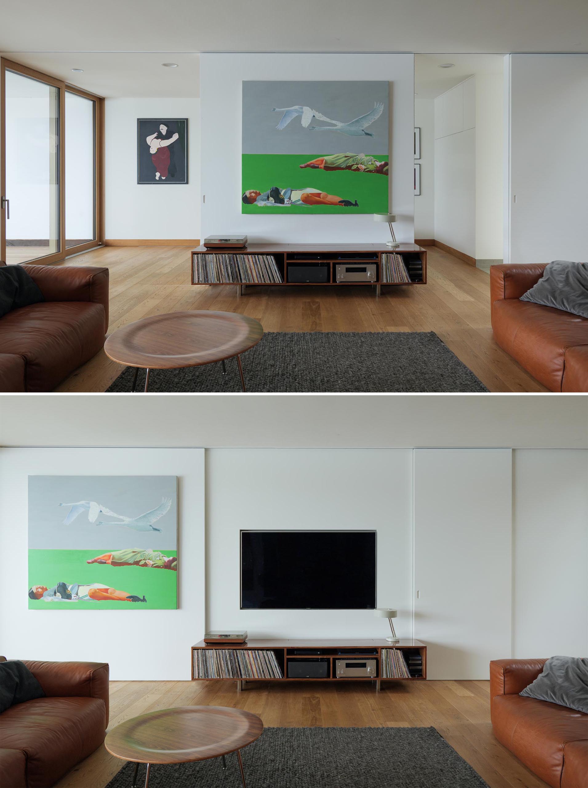 This modern TV room has a recessed television hidden from view behind a sliding wall.