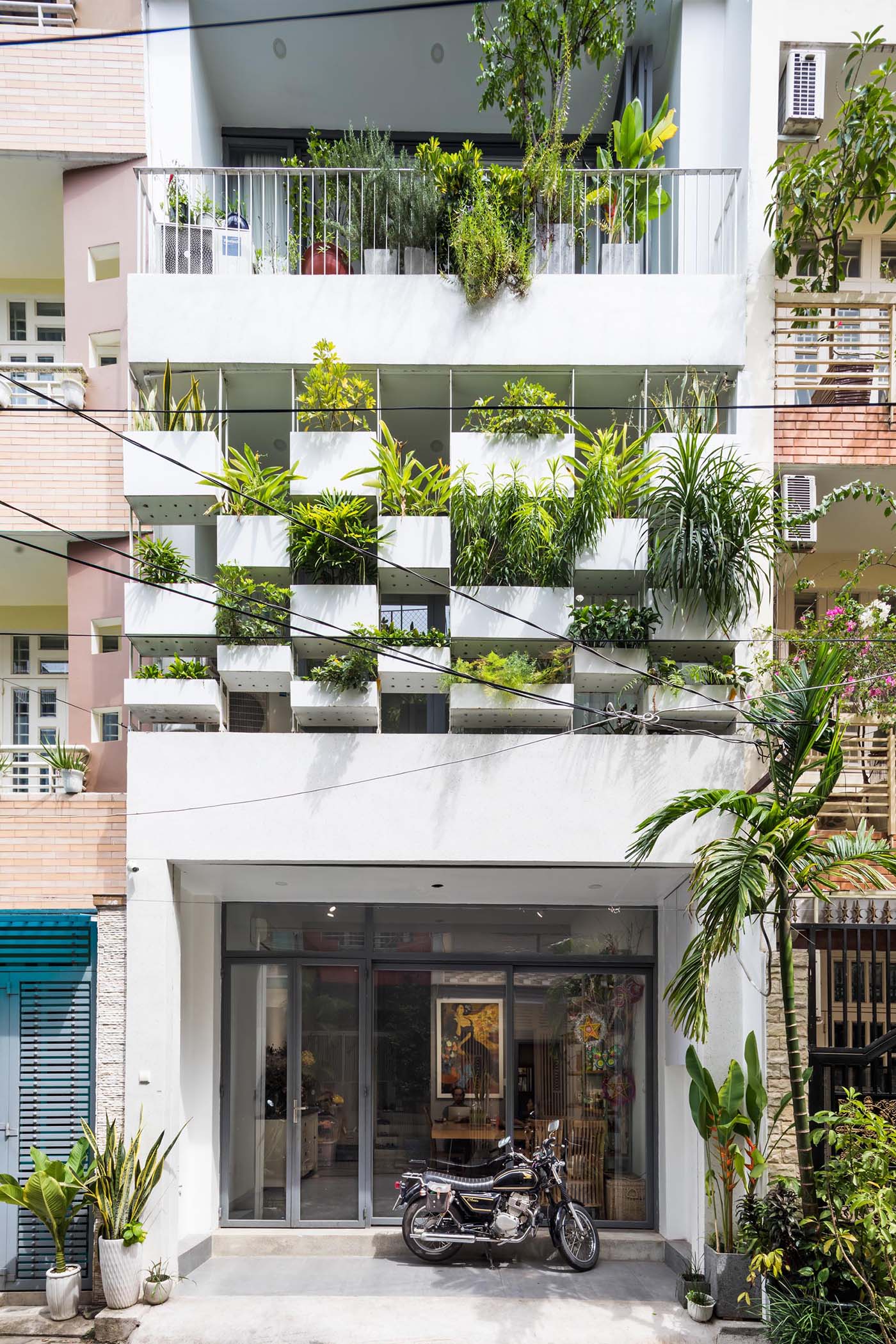 Planters have been added to the facade of this modern house, incorporating a  natural element into the concrete exterior.