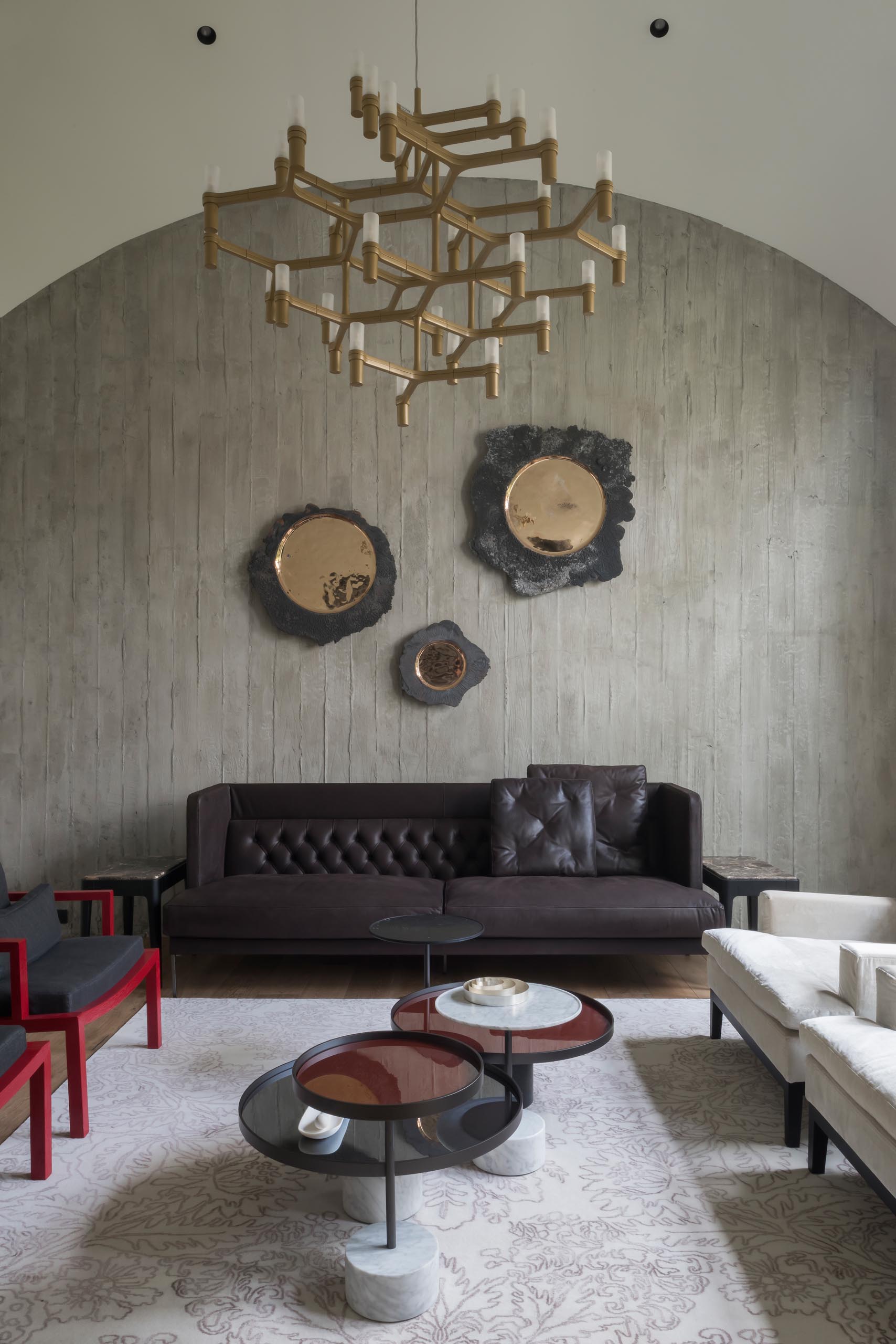 The living room has a curved ceiling, exposed concrete wall, and hardwood floors.