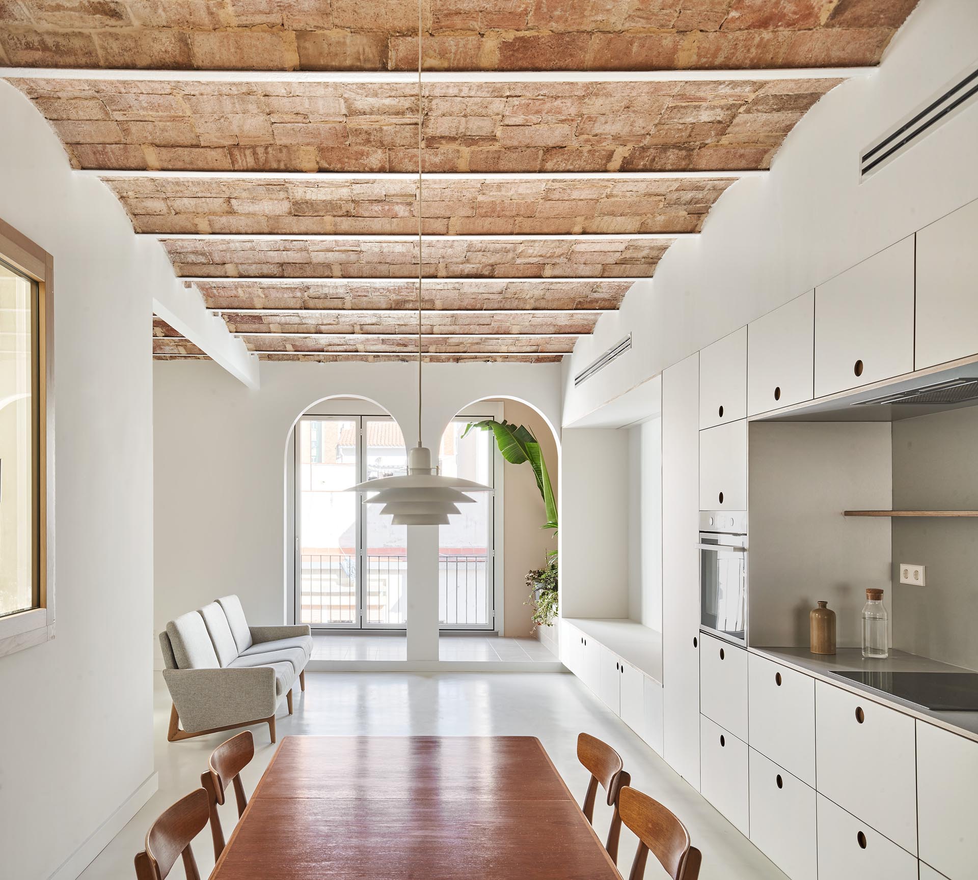 Minimalist kitchen and living room cabinets and drawers with recessed finger pulls.