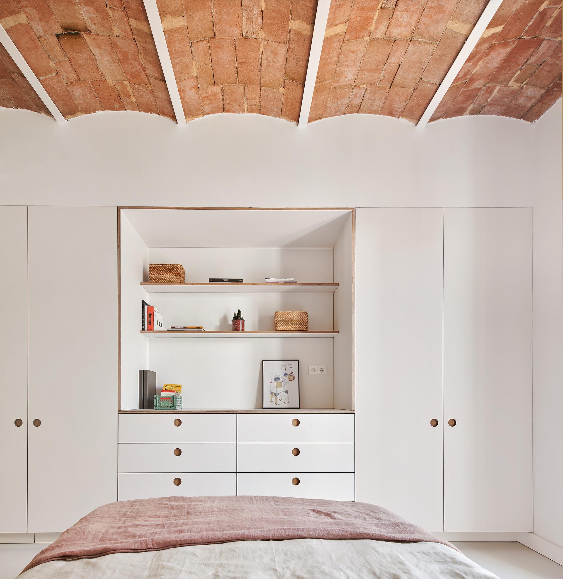 Minimalist bedroom closets and drawers with recessed finger pulls.