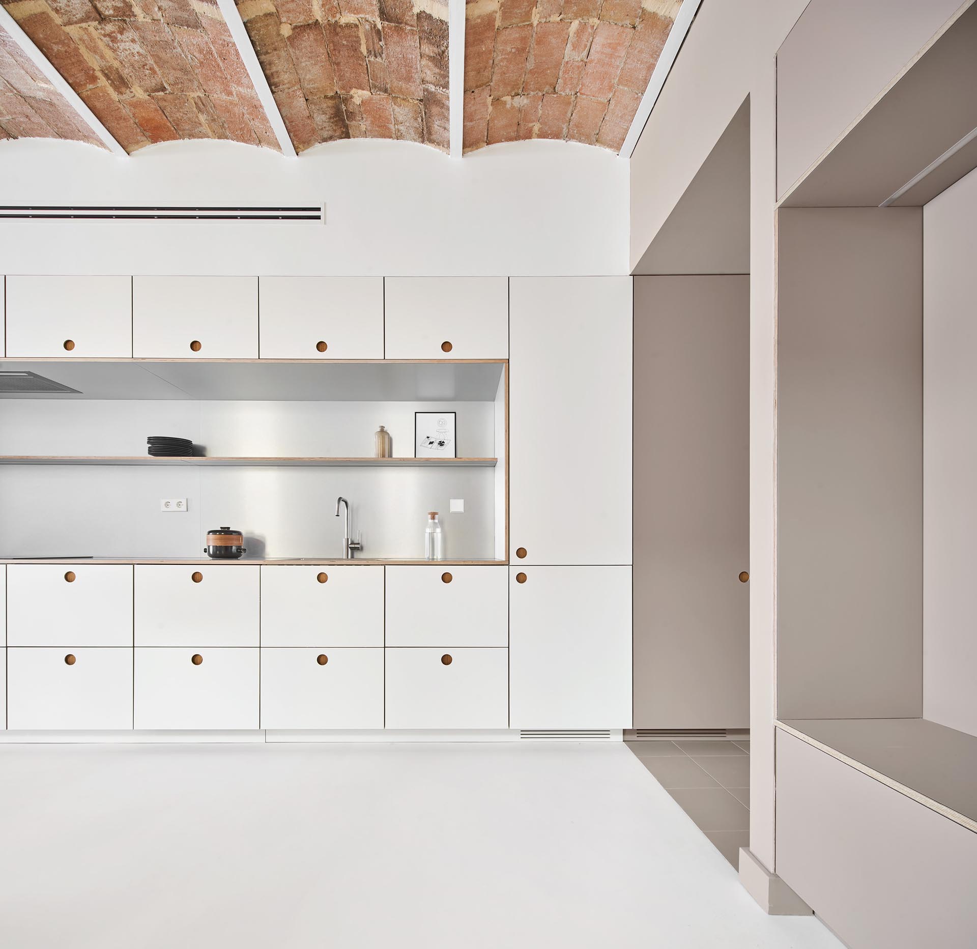 Minimalist kitchen cabinets and drawers with recessed finger pulls.