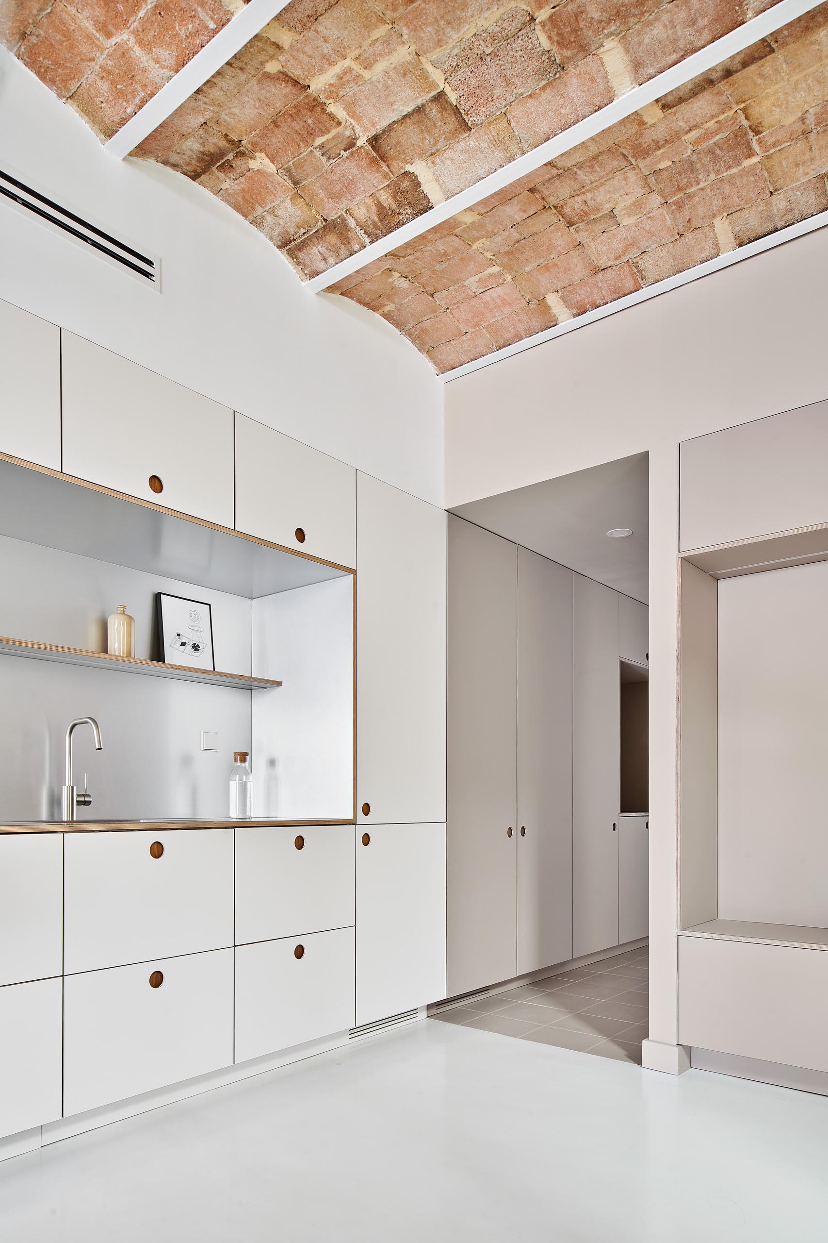 Minimalist kitchen cabinets and drawers with recessed finger pulls.