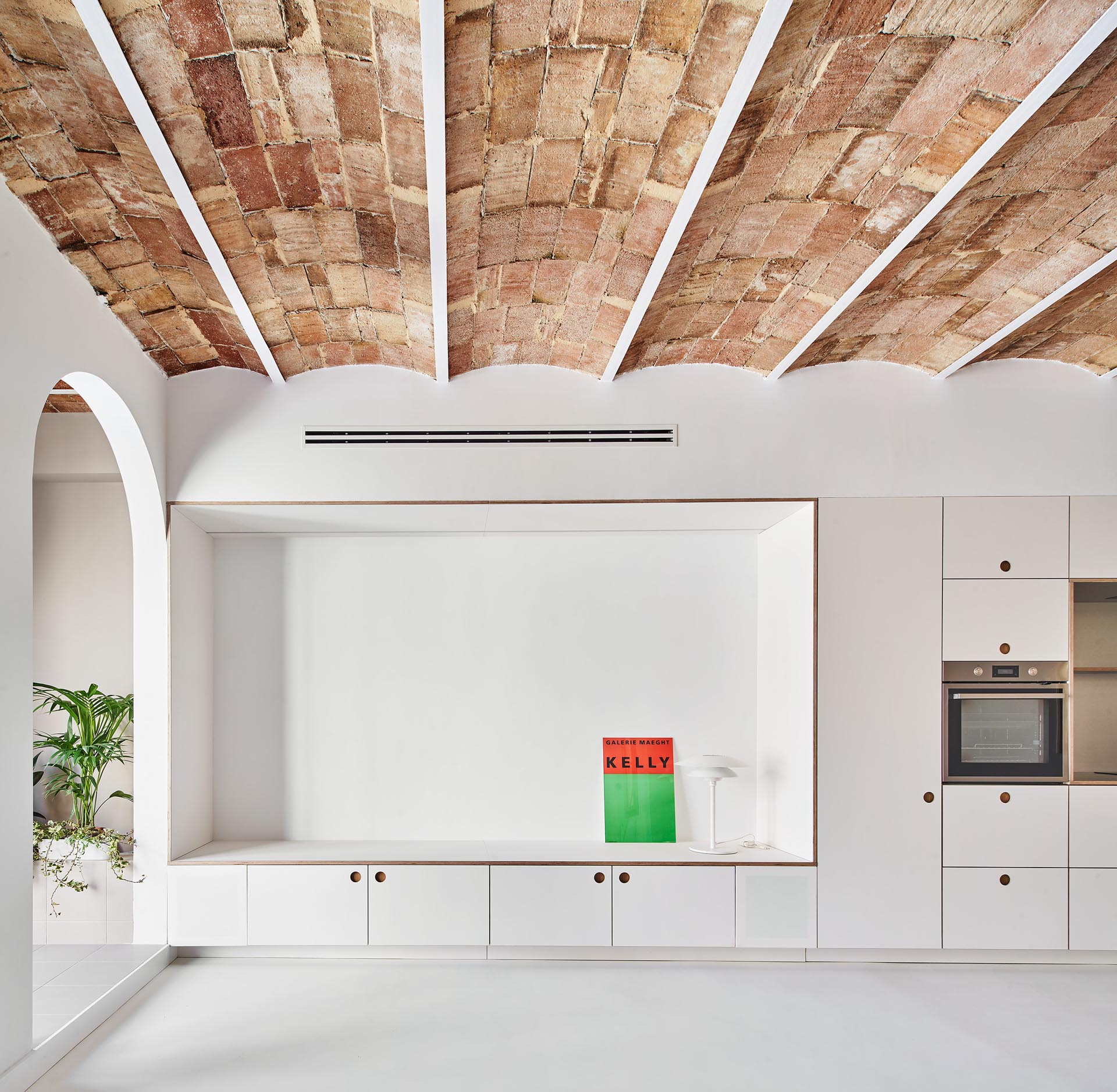 Minimalist kitchen and living room cabinets and drawers with recessed finger pulls.