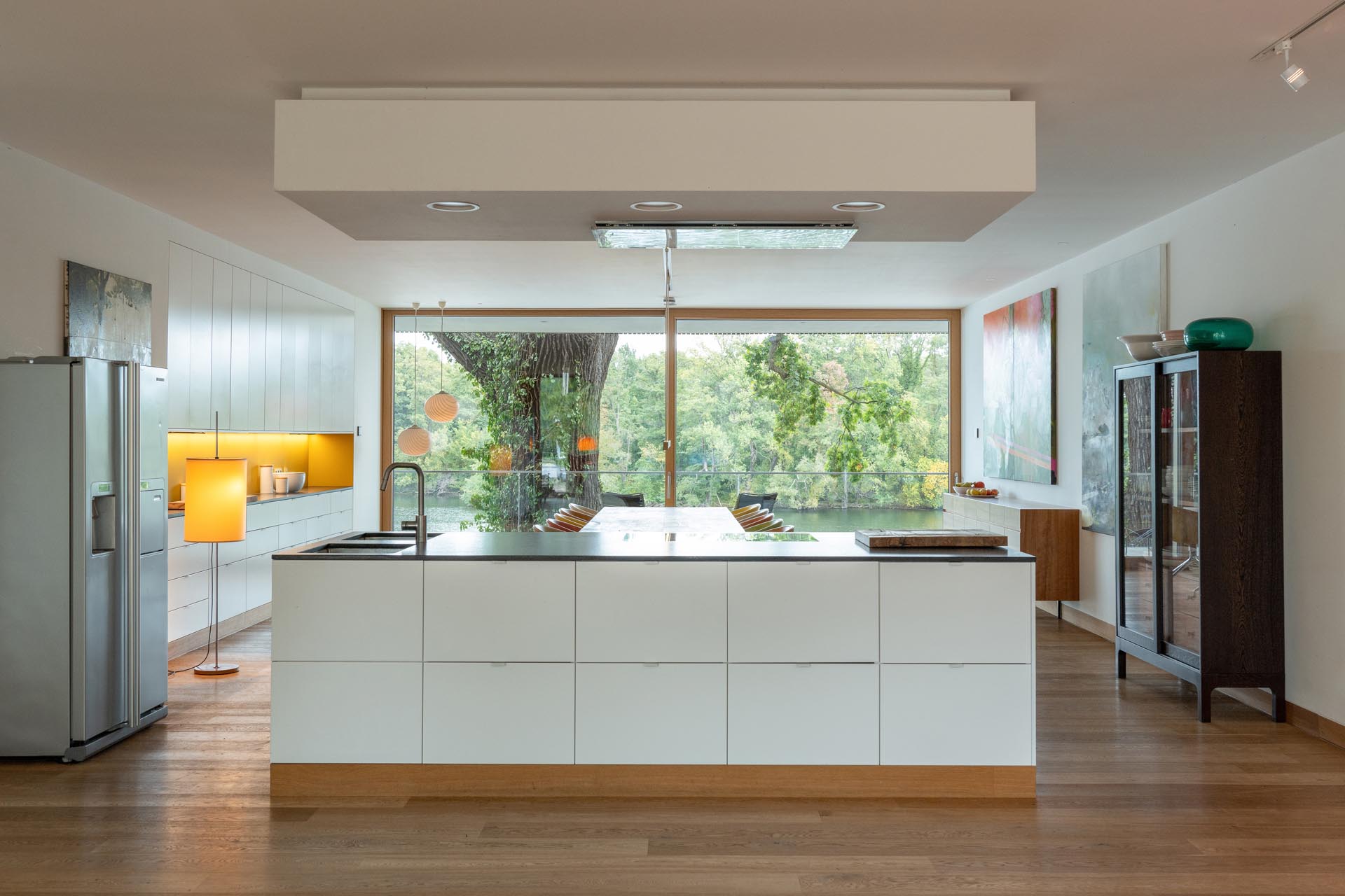 An open plan kitchen with a white island and dark countertop.