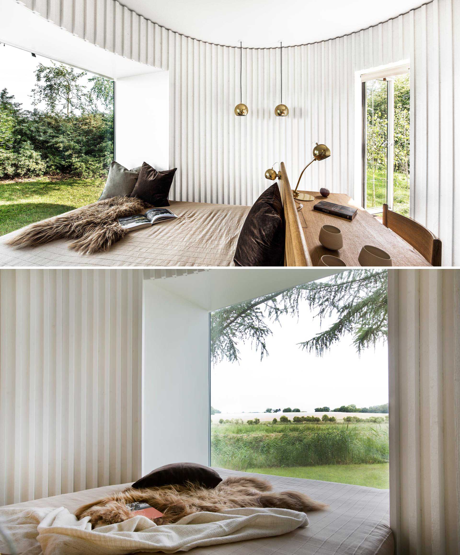 In this curved bedroom, a desk is positioned behind the headboard, while at the end of the is a picture window for unobstructed views.