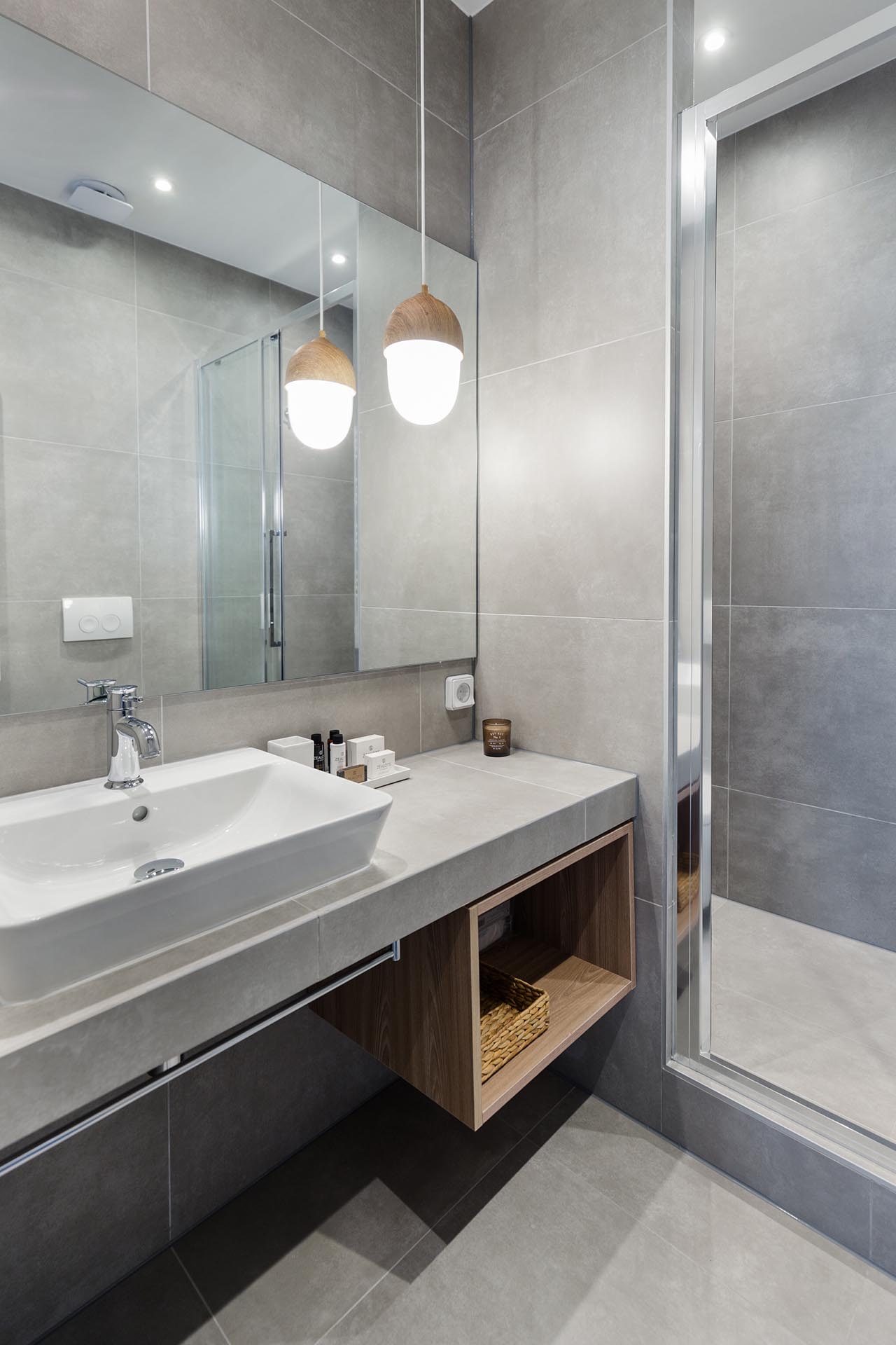 A small and modern bathroom with large format gray tiles.