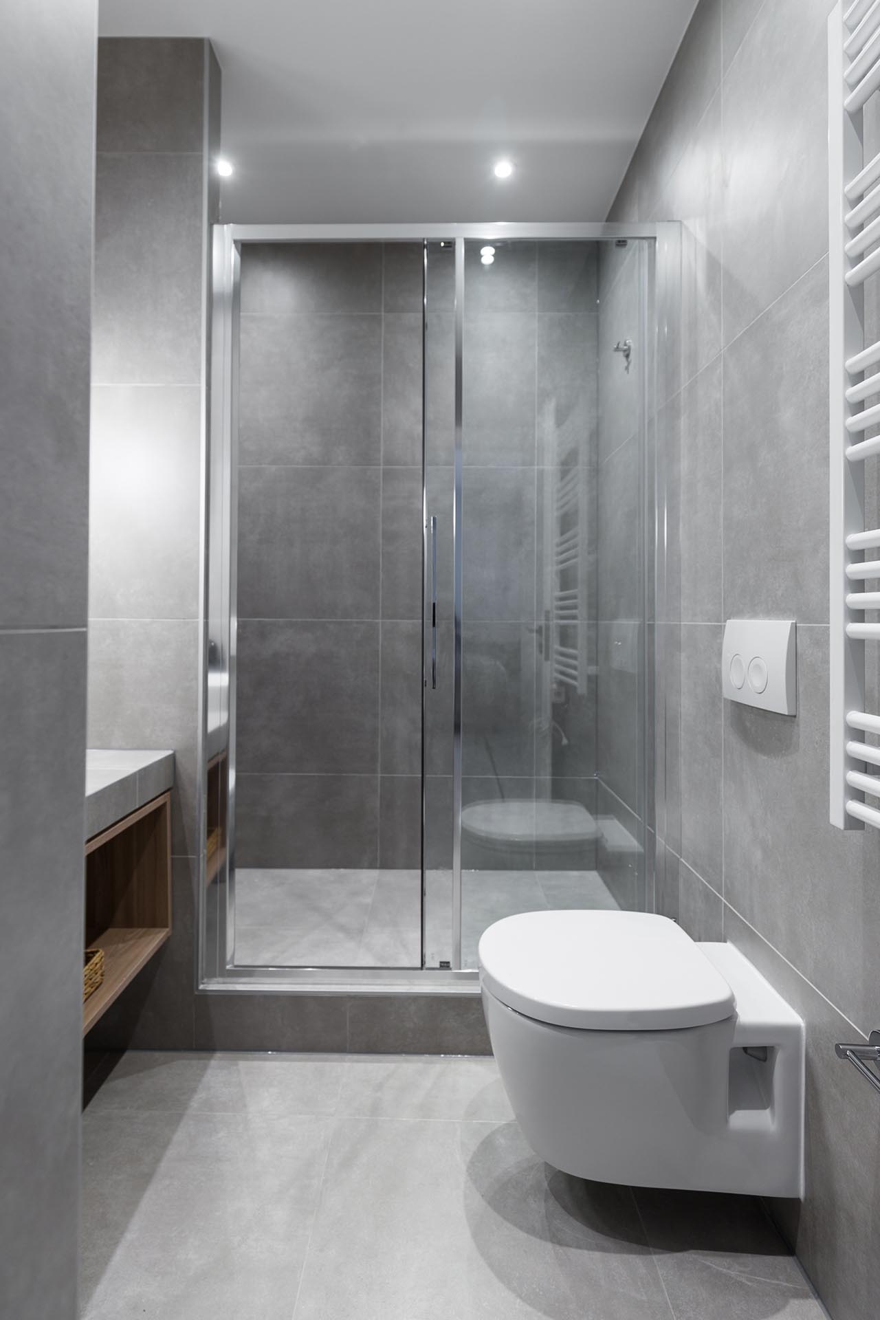 A small and modern bathroom with large format gray tiles.