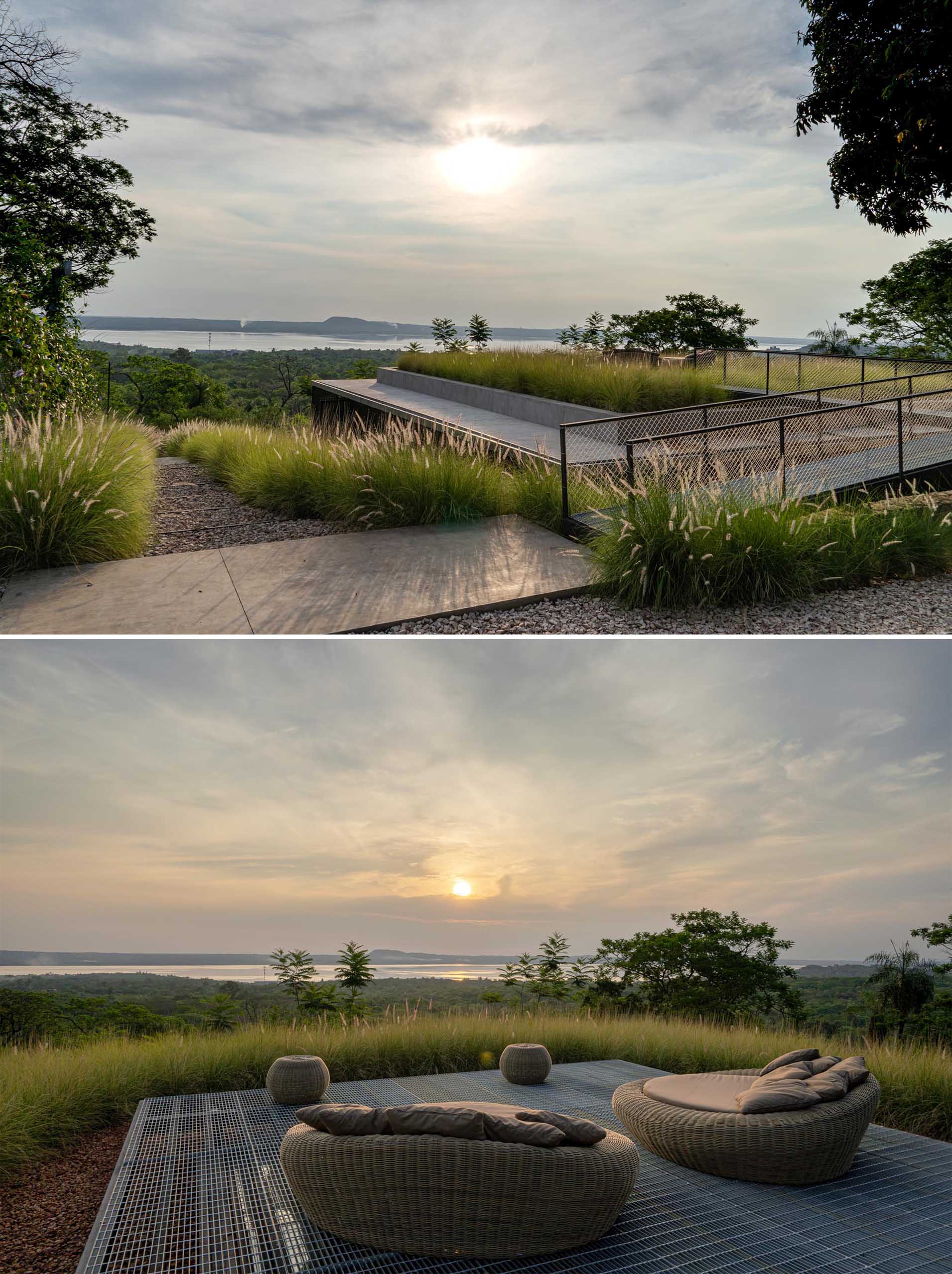 This modern rooftop patio is surrounded by grasses and is furnished with a pair of low day beds. From the rooftop, you can see the surrounding landscape and views of the water.