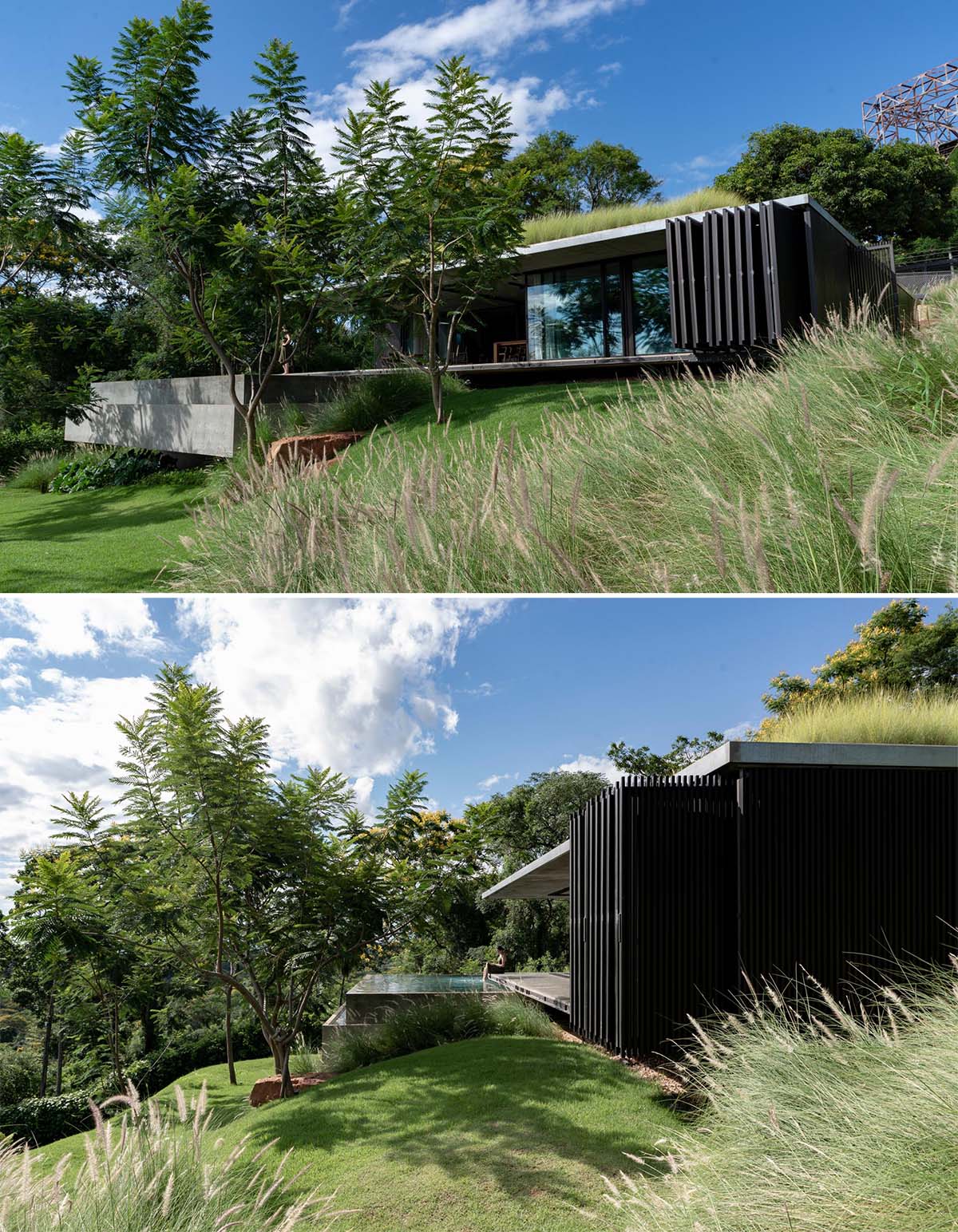 A modern house with a green roof that has folding black screens on its exterior.