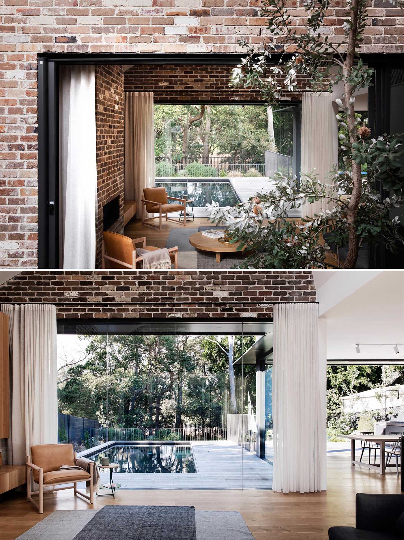 An additional glass wall in living room of a new home new addition provides views of the pool, while the opposite wall opens to a small courtyard with water-wise Australian native plants.