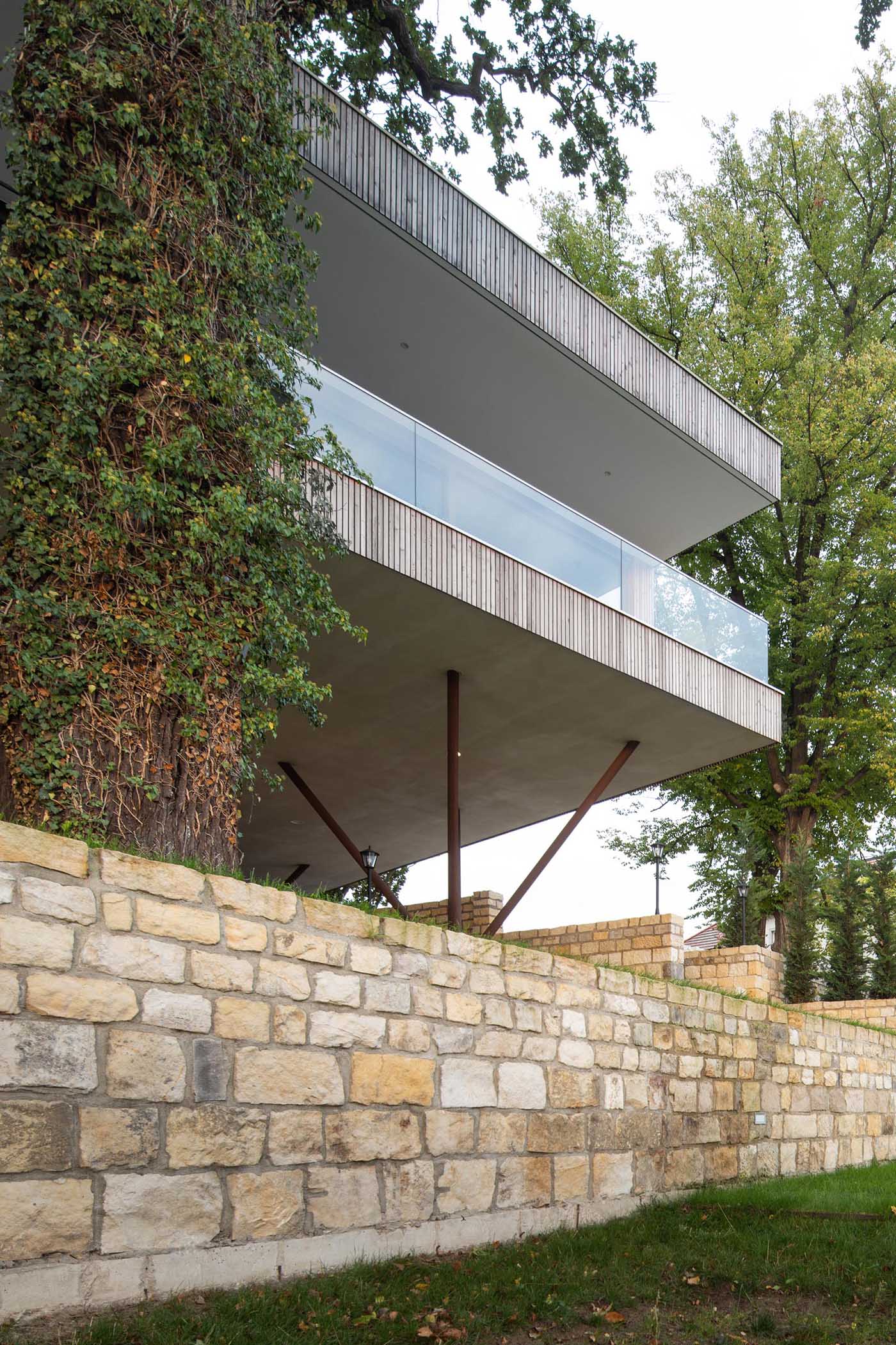 A modern house on poles has an exterior of vertical larch slats.