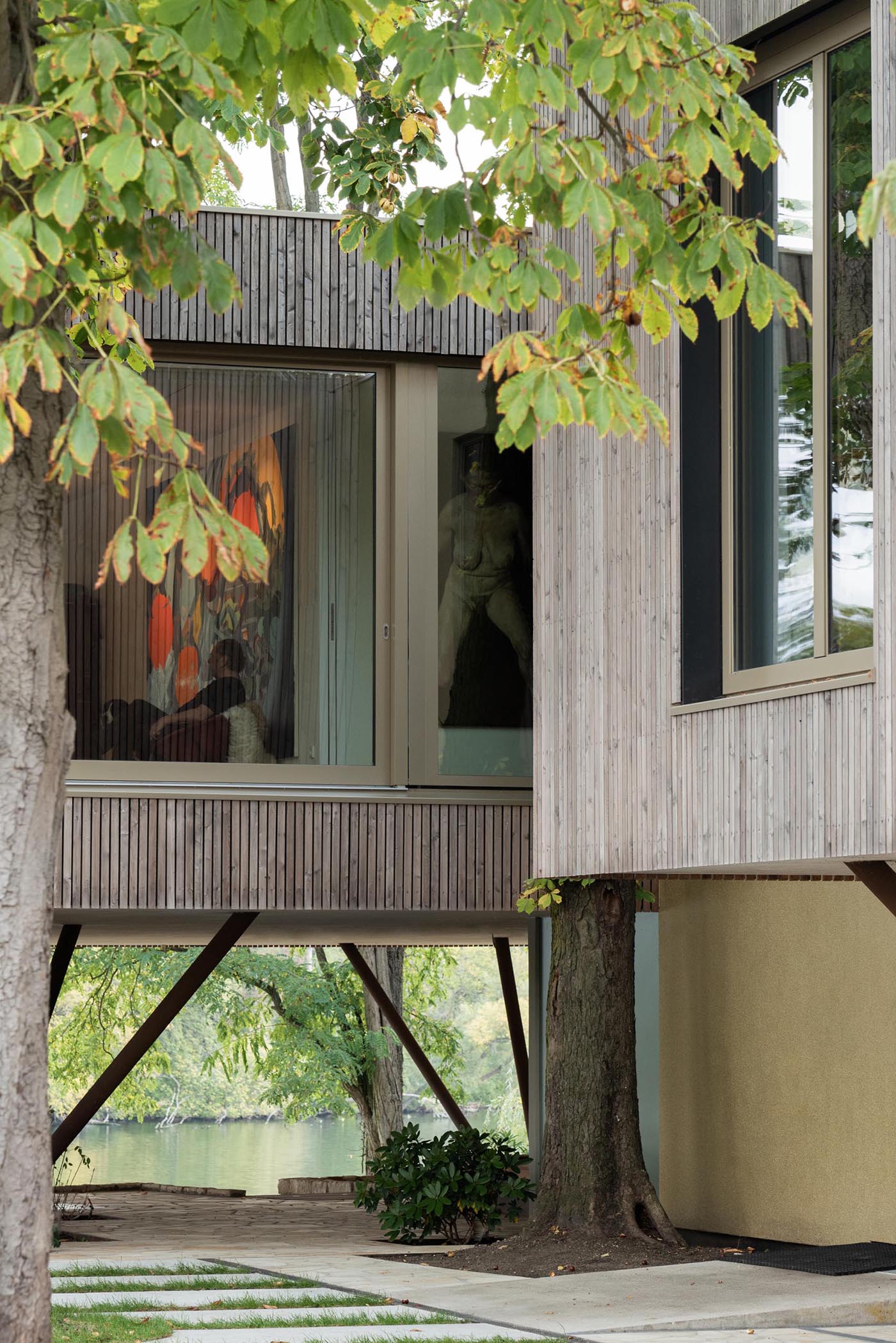 A modern house on poles has an exterior of vertical larch slats.